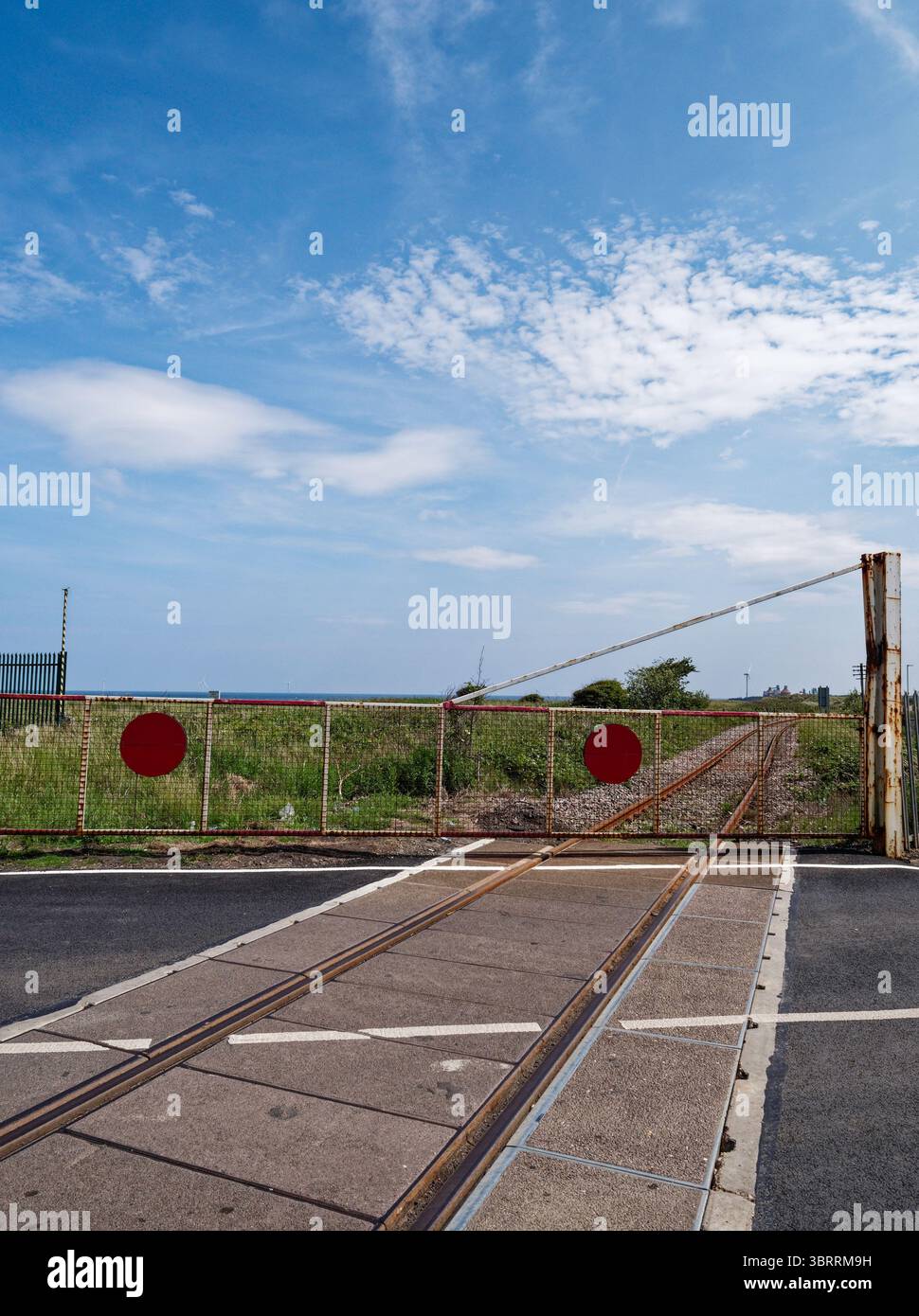 Bahnübergang mit geschlossenen Barrieren in North Blyth, Northumberland, Großbritannien. Stockfoto