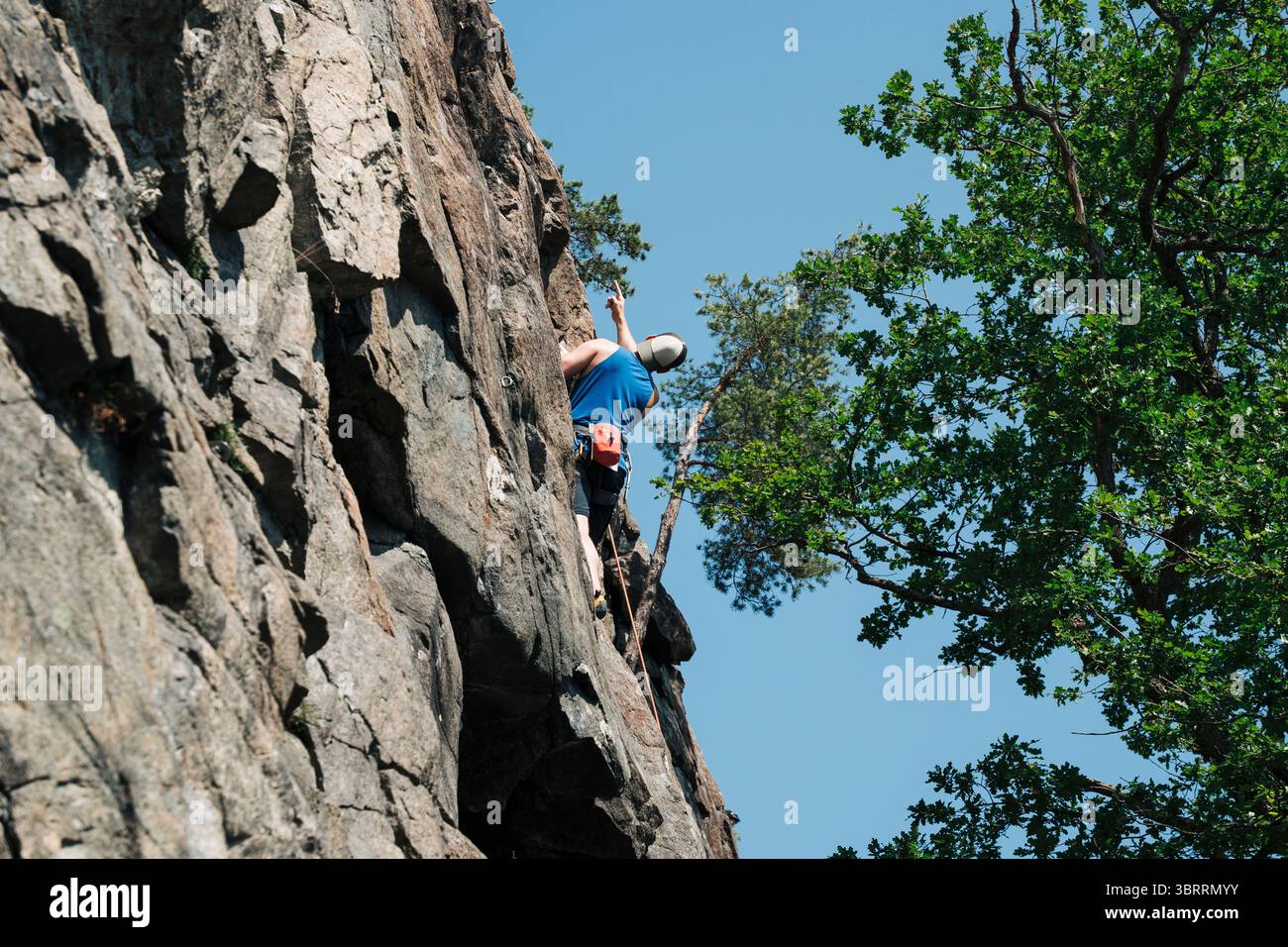 Er plant seine Route, während er draußen auf einem Felsen klettert Stockfoto