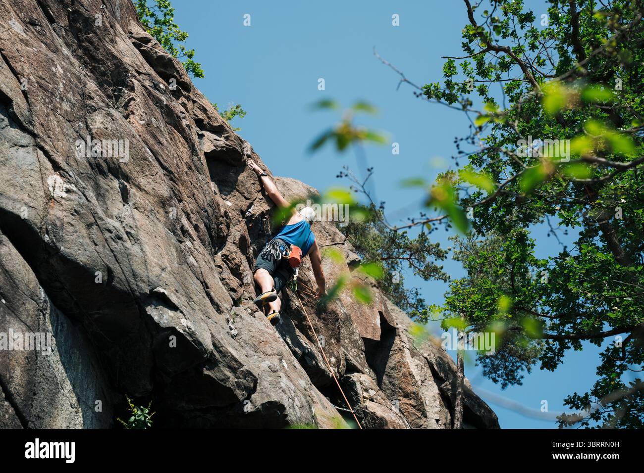 Ein Mann, der in Stockholm, Schweden, eine Felswand hochklettert Stockfoto
