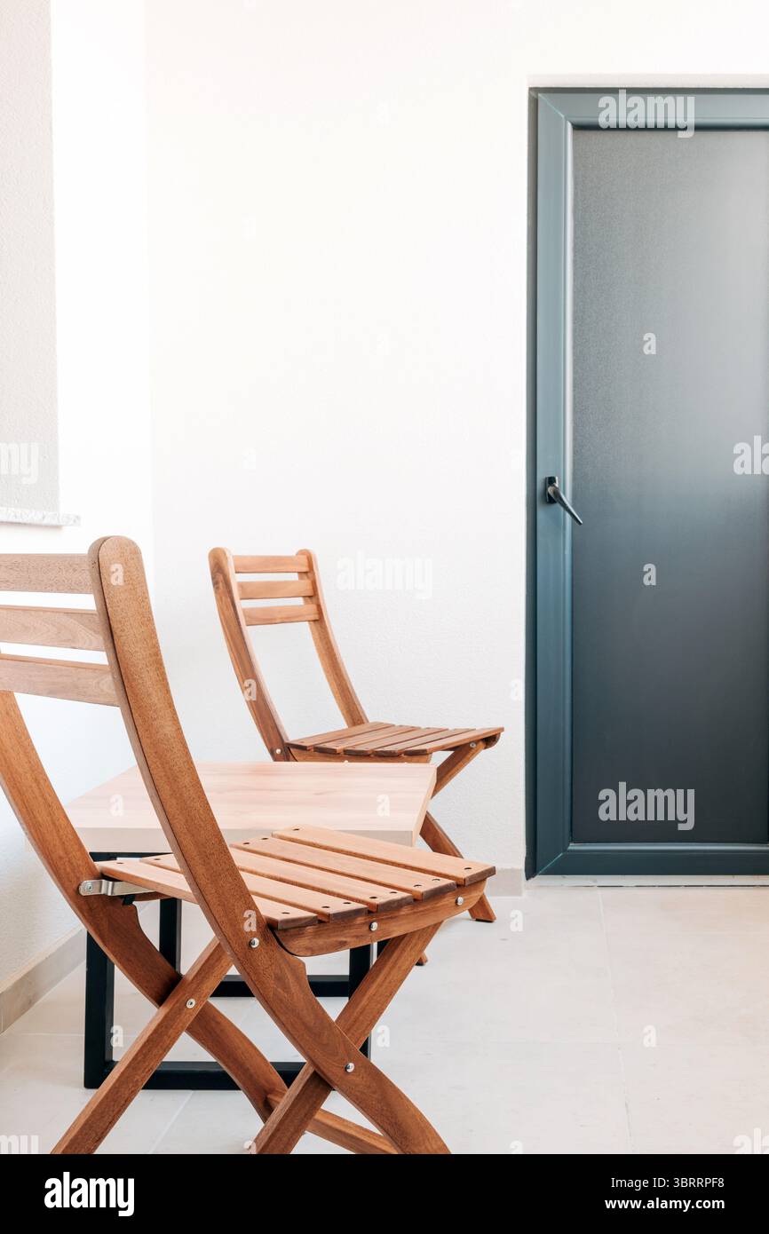 Holzstühle und Couchtisch auf dem Balkon des Apartments, selektiver Fokus Stockfoto