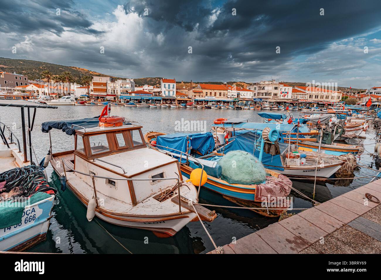 7. Mai 2025, Foca, Turkiye: Lebhafte Fischerboote mit Netzen und Planen an einem belebten Hafen Stockfoto