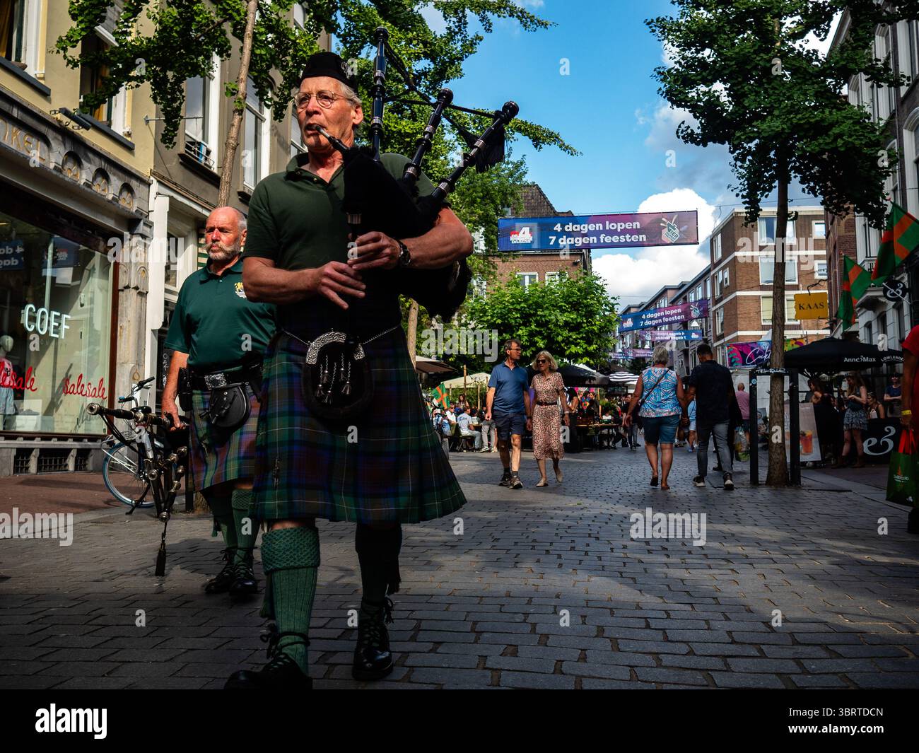 Nijmegen, Niederlande. Juli 2025. Ein Mann spielt Dudelsack, während er auf der Straße läuft. Diese Veranstaltung findet gleichzeitig mit den Internationalen vier-Tage-Märschen statt. Jedes Jahr präsentiert diese Veranstaltung ein vielseitiges Programm mit mehr als 1.000 Acts auf über 45 Bühnen, die alle völlig kostenlos sind und über 1,5 Millionen Menschen in die Innenstadt von Nijmegen locken. (Foto: Ana Fernandez/SOPA Images/SIPA USA) Credit: SIPA USA/Alamy Live News Stockfoto