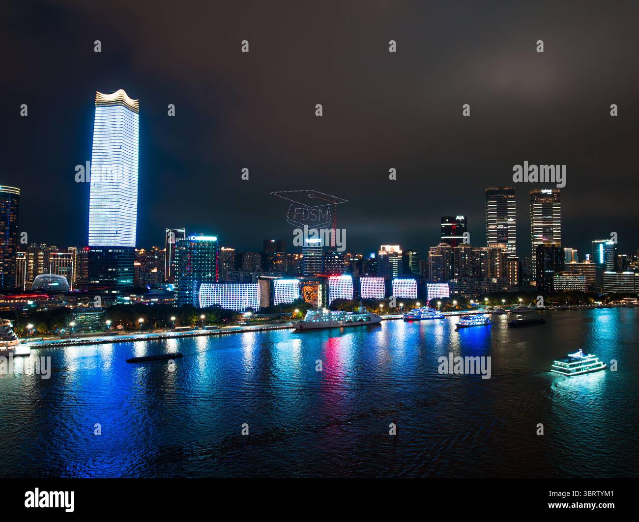 Shanghai, China - 21. Juni 2025: Aus der Vogelperspektive auf den Huangpu River, der die pulsierenden Lichter der Stadt vor dem dunklen Himmel reflektiert, und der ikonische Oriental Pearl Tower leuchtet hell. Stockfoto