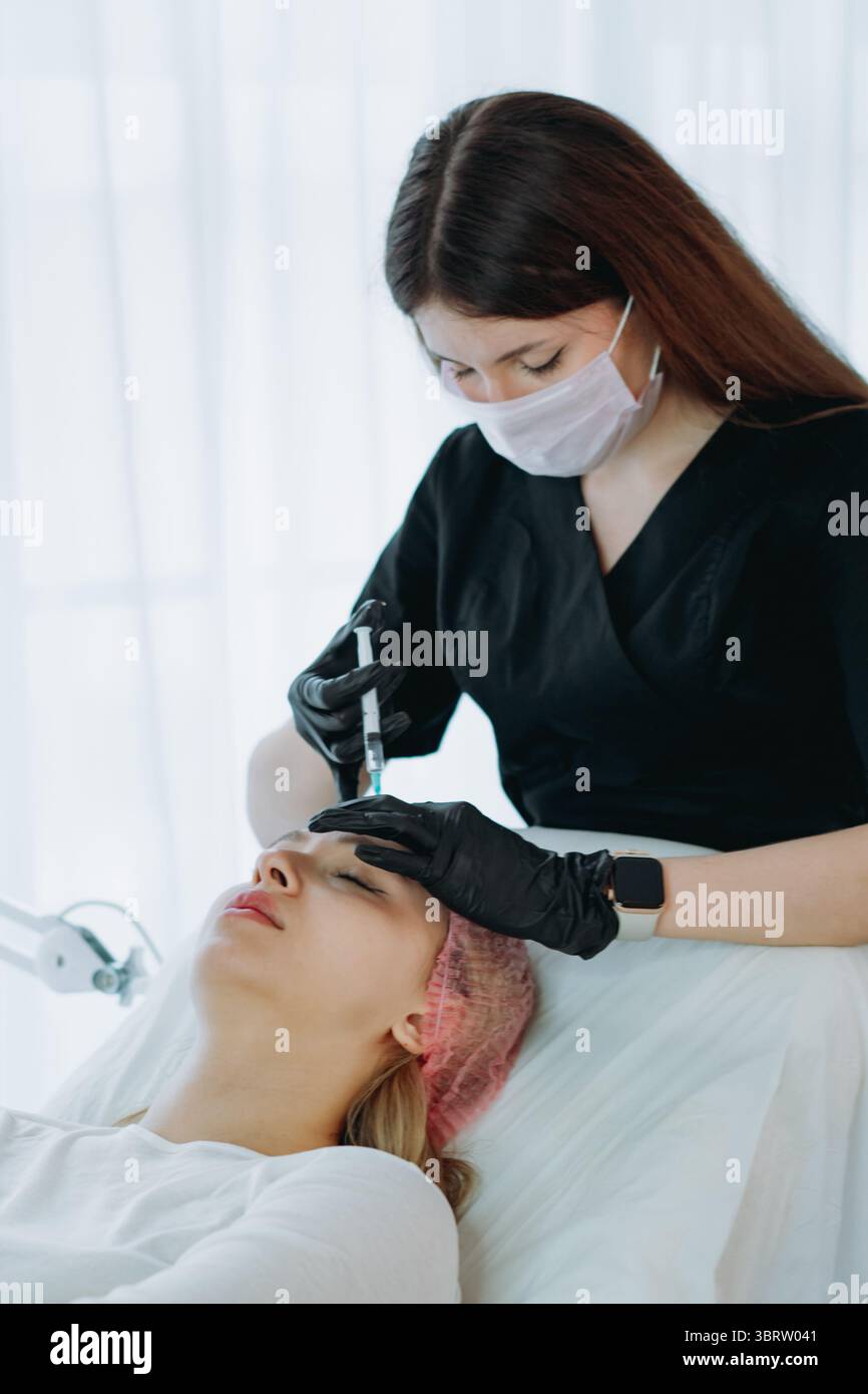 Ein ästhetischer Fachmann, der ein Botox-Injektionsverfahren im Glabellarbereich durchführt. Schönheitsbehandlung. Hochwertige Fotos Stockfoto