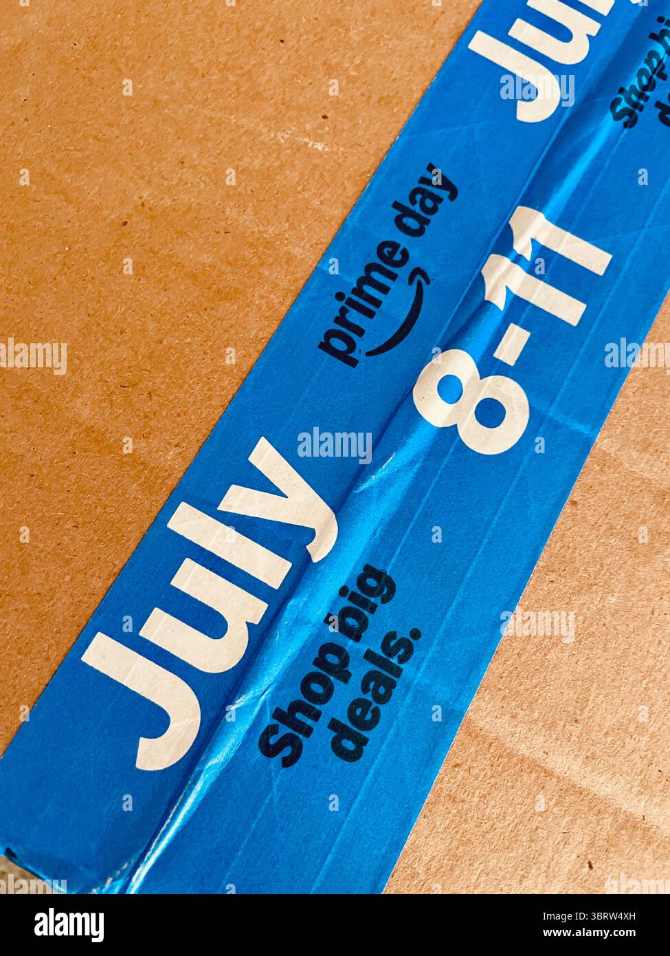 Die Versandbox von Amazon enthält ein Bright Blue Tape zur Ankündigung des Prime Day vom 8. Bis 11. Juli 2025, USA - Smartphone-aufgenommenes Stockfoto