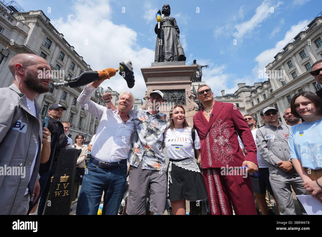 Der Weltmeister im Schwergewicht Oleksandr Usyk und Sir Richard Branson mit Eddy Scott und Ruslana Danilkina, die beide im Ukraine/Russland-Konflikt vor der Statue der Florence Nightingale in Waterloo Place, St. James's, London, während eines Fotorufs für das Superhuman Center Gliedmaßen verloren haben. Bilddatum: Montag, 14. Juli 2025. Stockfoto