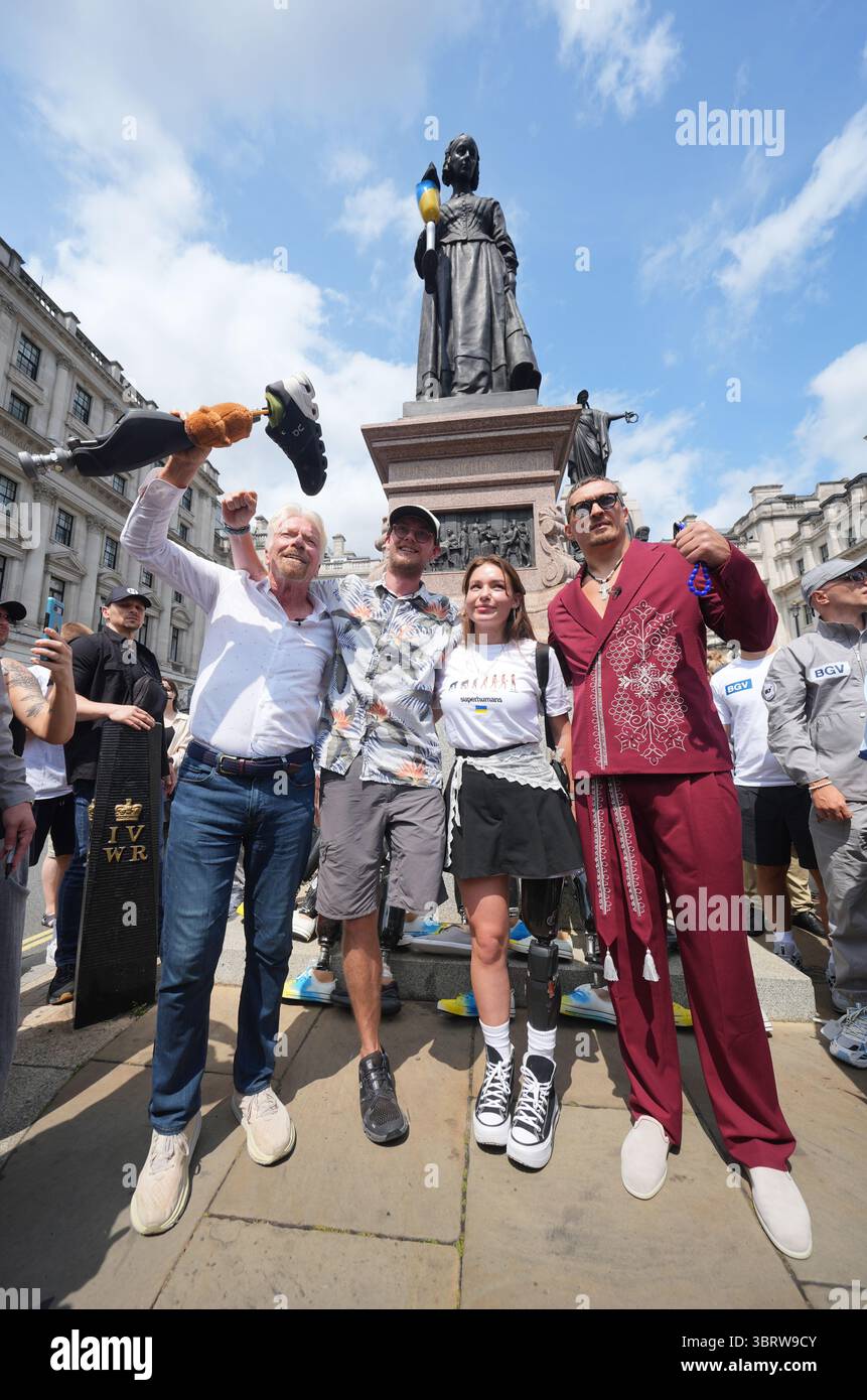 Der Weltmeister im Schwergewicht Oleksandr Usyk und Sir Richard Branson mit Eddy Scott und Ruslana Danilkina, die beide im Ukraine/Russland-Konflikt vor der Statue der Florence Nightingale in Waterloo Place, St. James's, London, während eines Fotorufs für das Superhuman Center Gliedmaßen verloren haben. Bilddatum: Montag, 14. Juli 2025. Stockfoto