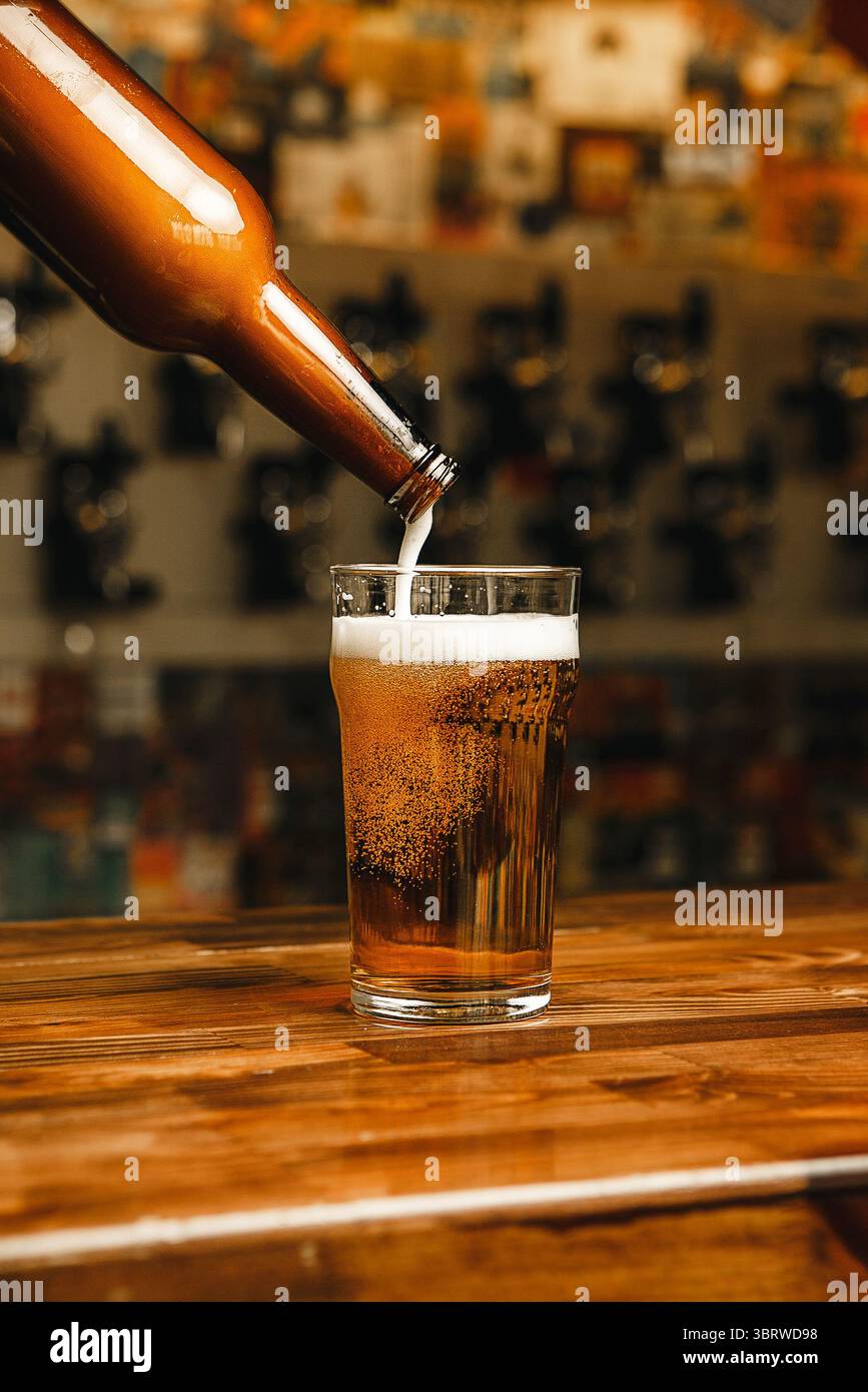 Gießen Sie den letzten Tropfen Bier mit Schaum in Glas Stockfoto
