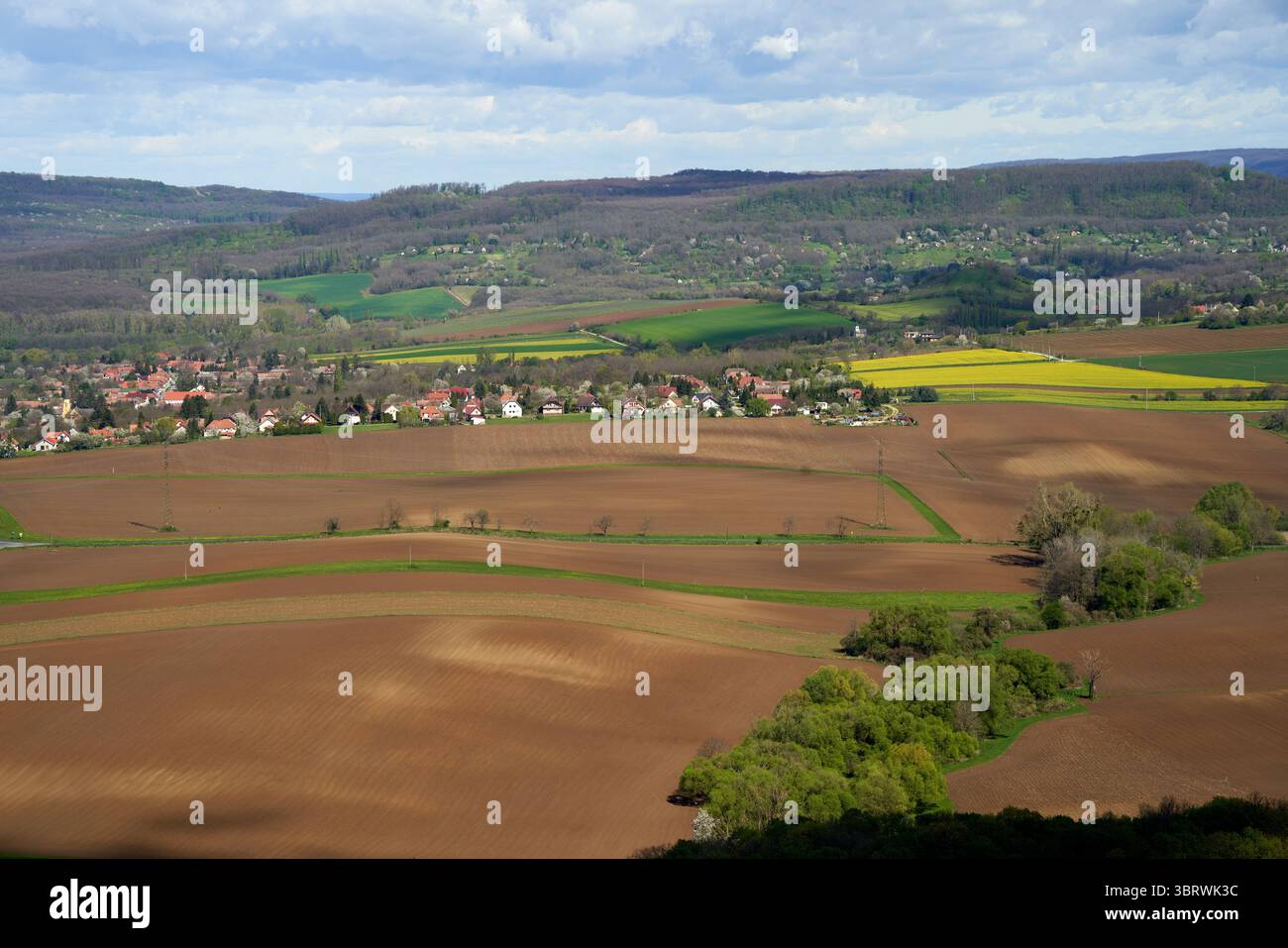 Landschaft des ländlichen Ungarns während des Frühlings, um Ostern, landwirtschaftliche Felder, Dorf mit Einfamilienhäusern, Weinberge und Wald in der Ferne Stockfoto