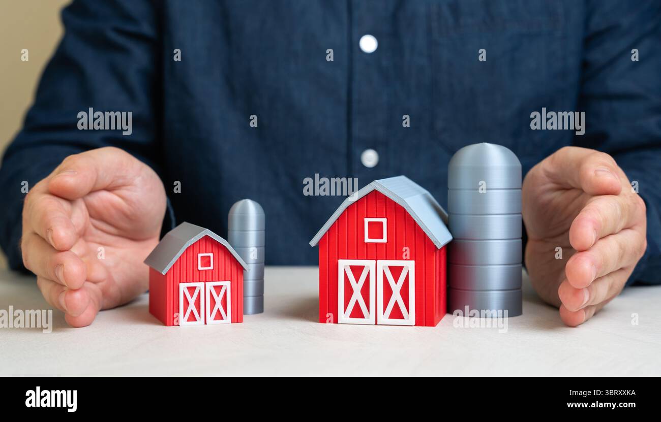 Ein Mann beschützt eine große und kleine Farm mit seinen Händen. Schutz der landwirtschaftlichen Betriebe. Unterstützung der Landwirtschaft in vollem Umfang. Gerechte Politik, Widerstandsfähigkeit gegen Glo Stockfoto