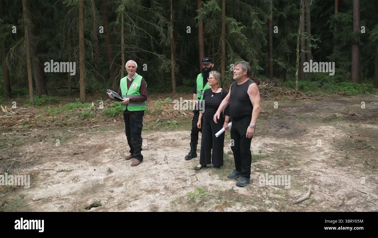 Hermsdorf, Deutschland. Juli 2025. Günter Peupelmann (r) von der Bürgerinitiative Holzland steht in einem Waldgebiet mit Mitgliedern anderer Bürgerinitiativen. Er versucht politischen Einfluss auszuüben – als stellvertretender Bürgermeister der Stadt Hermsdorf und Mitglied des Landkreises Saale-Holzland. Mehrere Bürgerinitiativen kämpfen seit Jahren gegen die Windturbinenpläne im Wald bei Eineborn und St. Gangloff in Ostthüringen. Quelle: Mike Müller/dpa/Alamy Live News Stockfoto