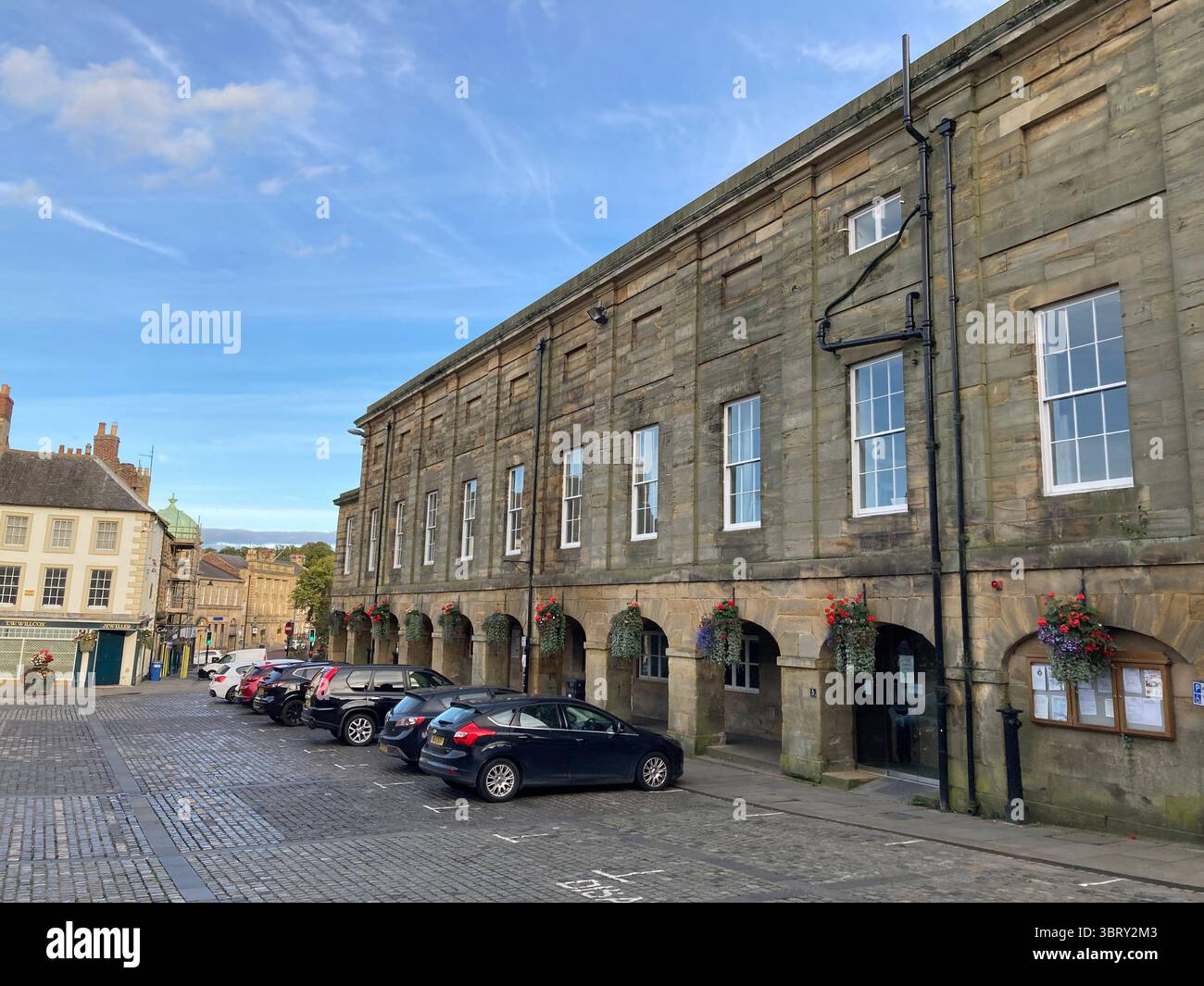 Historische Szene des Hexham Markts mit einer alten Abtei und mittelalterlichen Straßen, die im Herbstlicht getaucht sind Stockfoto
