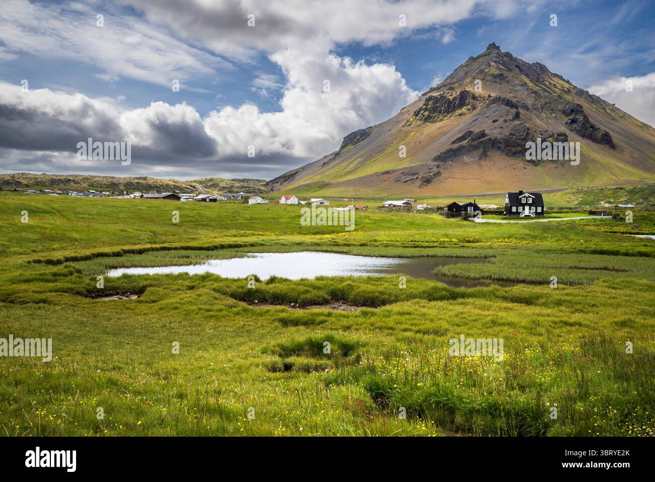 Arnarstapi Dorf mit Stapafell Vulkanberg im Hintergrund, Westisland Stockfoto