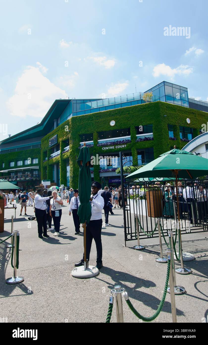 Vor dem Eingangstor Nummer 5 mit Sicherheitspersonal und dem Äußeren des Centre Court All England Lawn Tennis Club Wimbledon London England UK Stockfoto