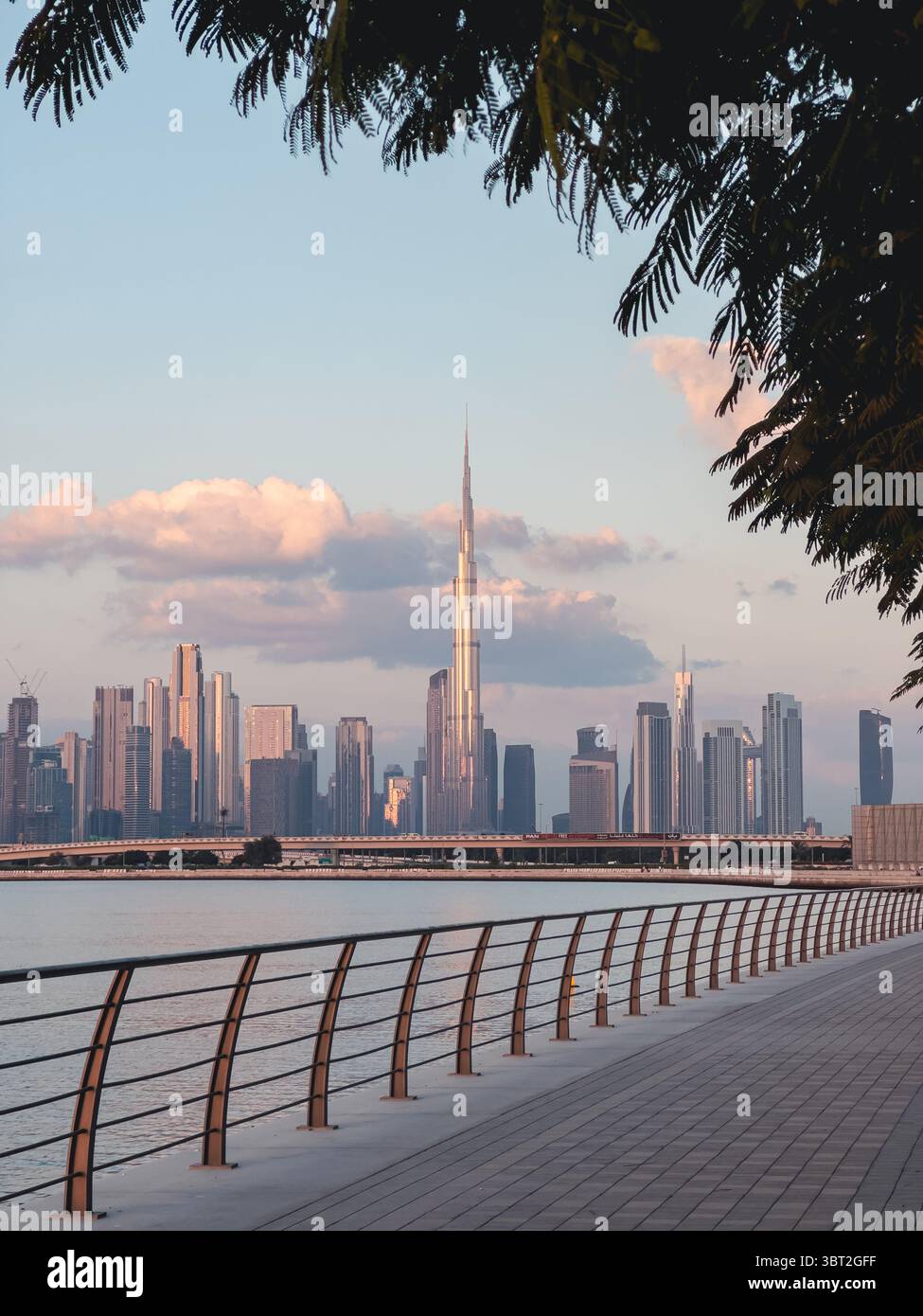 Vertikales Stockfoto der Skyline von Dubai und Blick auf das Wasser in der Abenddämmerung mit Sonnenuntergang Stockfoto