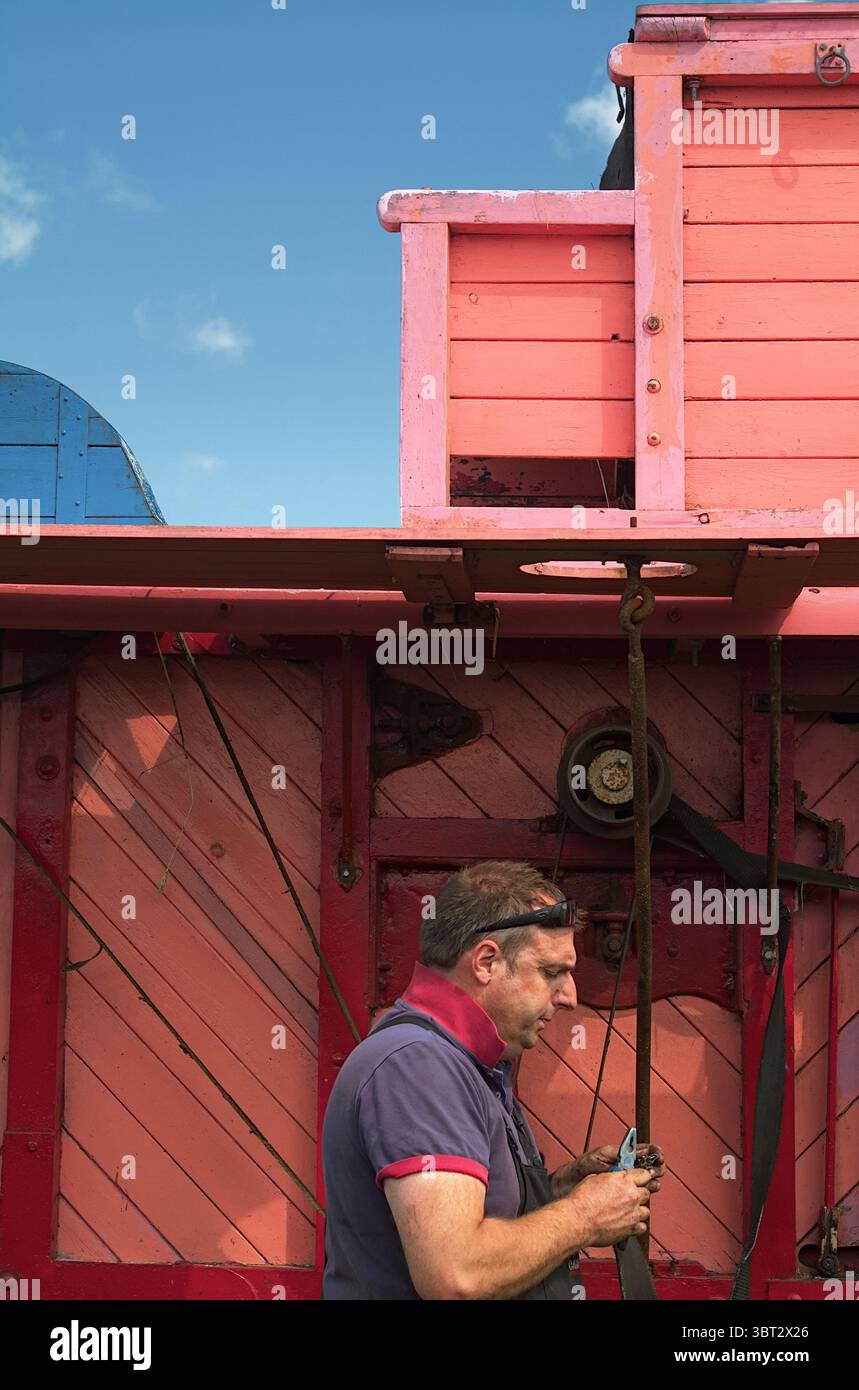Mann, Farm Worker repariert Eine dampfbetriebene Vintage, restauriert, alte Maisdreschmaschine, New Forest UK Stockfoto