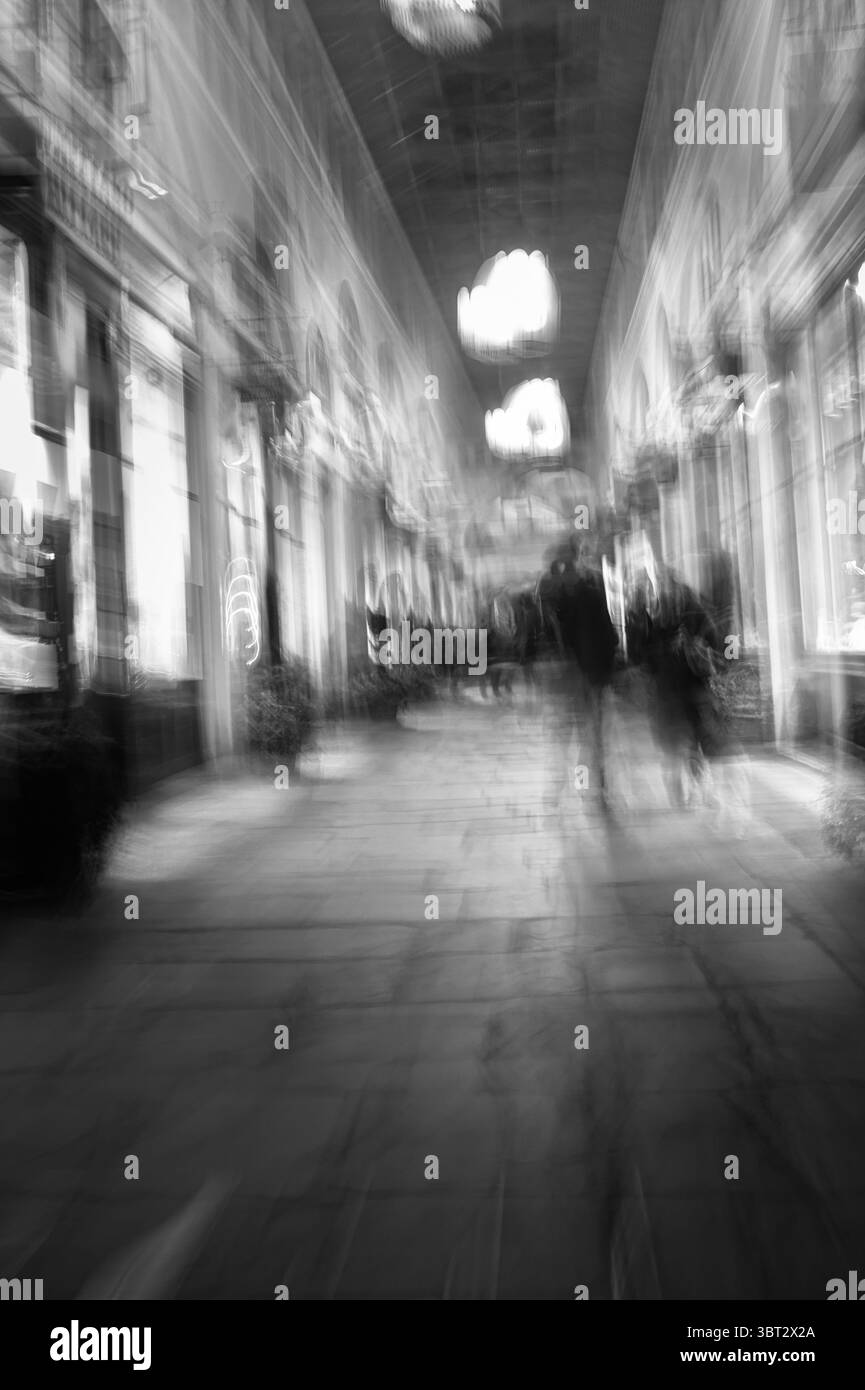 Monochrom, Schwarzweiß Der Menschen, Shopper, Die An Den Geschäften Im Colonnade Shopping Area Covent Garden Market Mit Absichtlicher Kamera Mo Vorbeilaufen Stockfoto