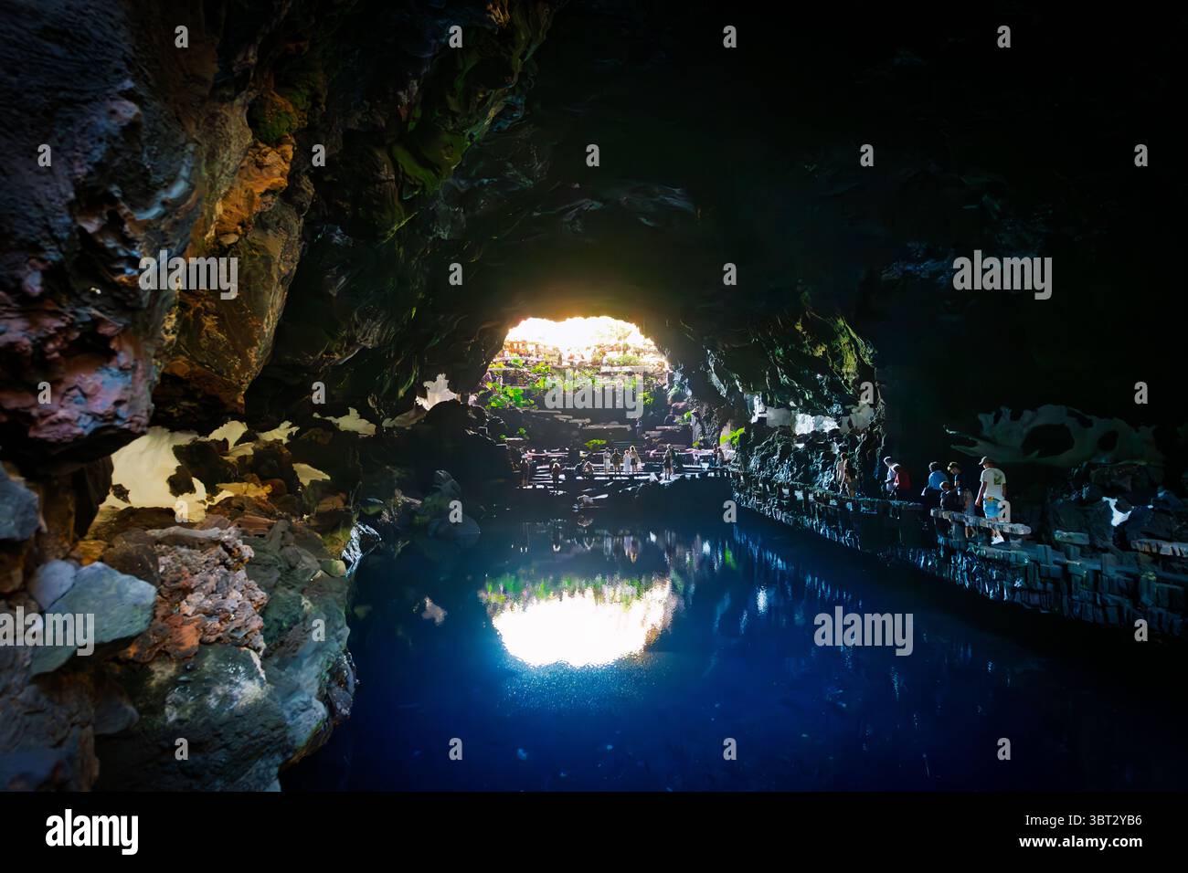Touristen besuchen die Jameos del Agua Lavaröhrenhöhle im César Manrique Volcano House in Tahiche, Spanien, auf der Kanarischen Insel Lanzarote. Stockfoto