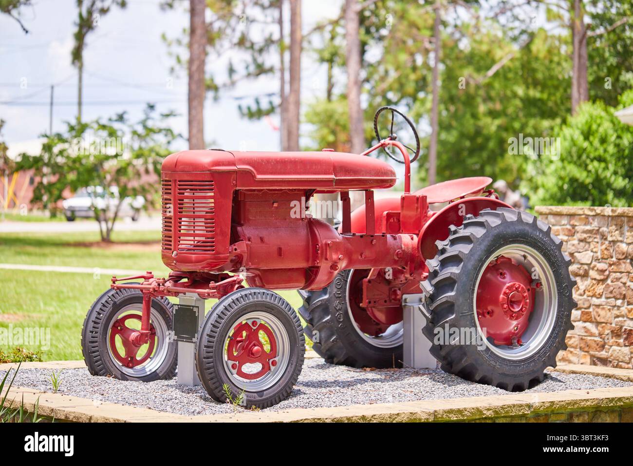 Central Park in der Gemeinde Lakeland, GA USA, mit einer Bogenbrücke über einen Teich, der United States Flag und einem alten internationalen Traktor! Stockfoto