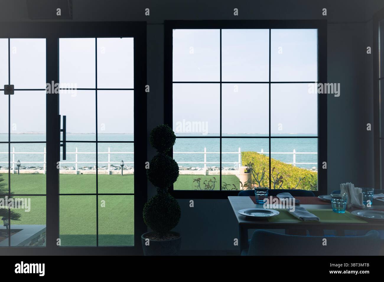 Panoramablick auf den Strand vom Fenster des Restaurants, Blick auf den Strand von einem französischen Fenster Stockfoto