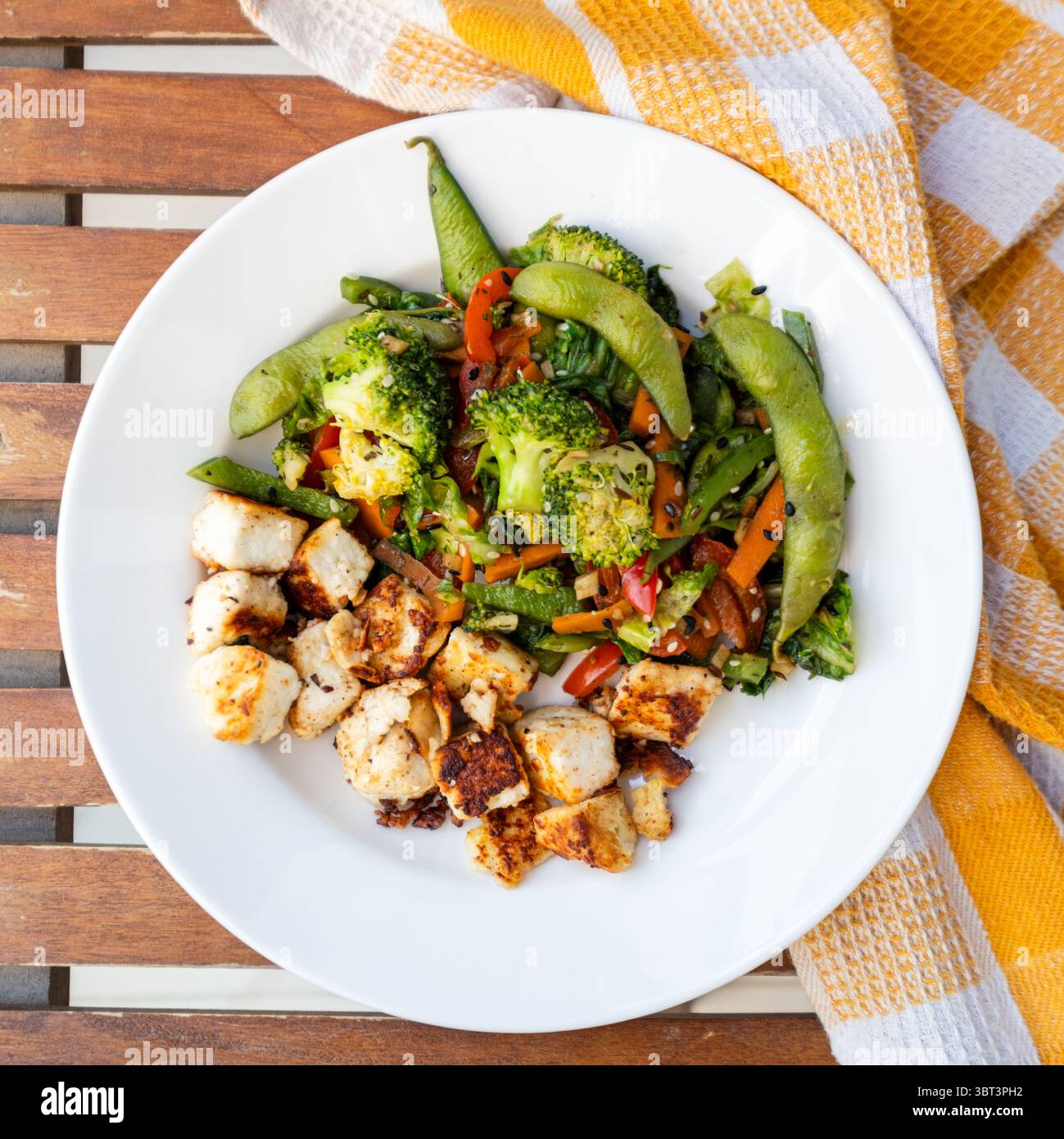 Edamame und Brokkoli-Rührbraten mit Tofu, Seidentofu mit gebratenem Gemüse in einem weißen Keramikblock, asiatische Premium-Lebensmittelfotografie Stockfoto