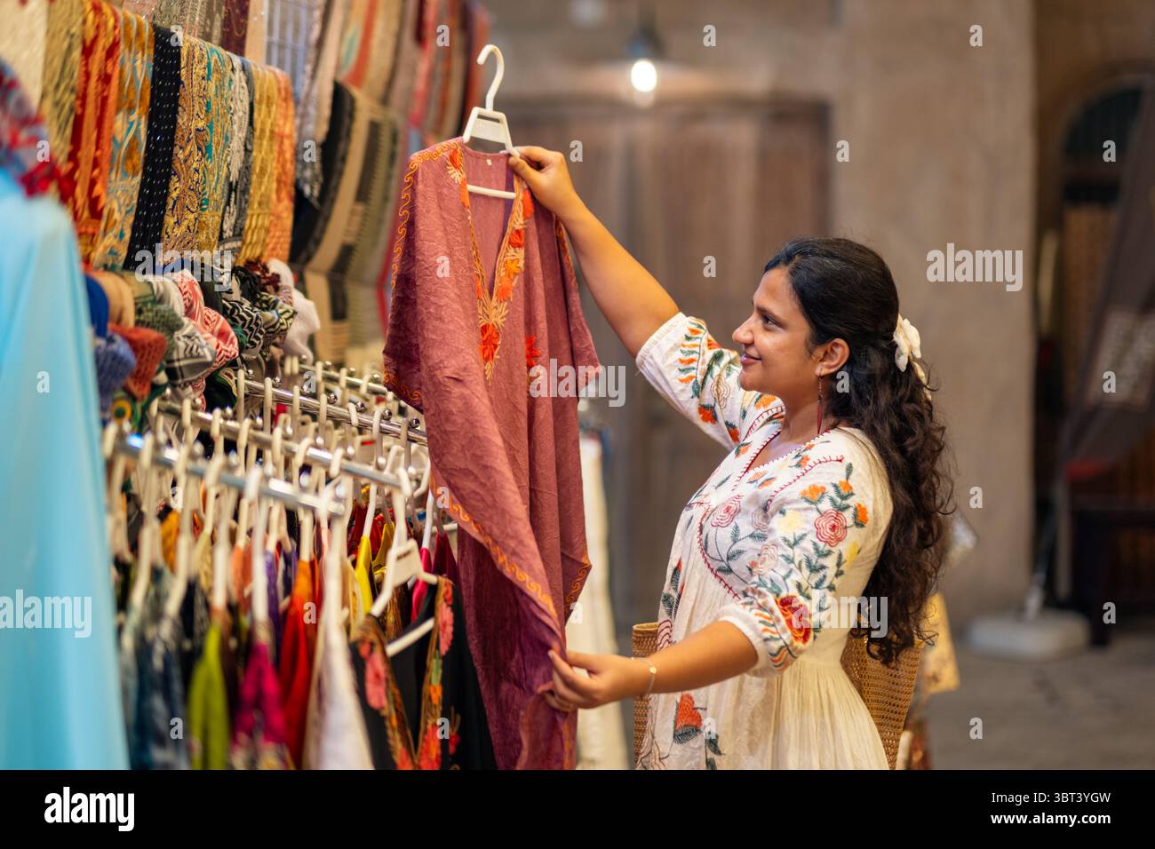 Die junge asiatische Frau, die in Mumbai auf der Fashion Street shoppt, sieht sich wunderschöne Kleider im Kaftan-Stil an Stockfoto