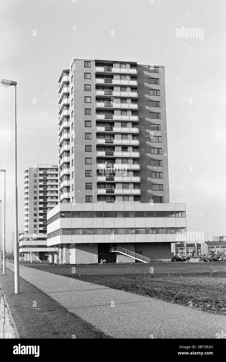 Tower Blocks on Robert Kochlaan Haarlem Robert Kochlaan The Netherlands, Whizgle News, Dutch Desk, Niederlande, 1950 - 2000 am 23-11-1971. Dies sind die Themen im Bild. Die Szene verfügt über ein modernes Gebäude, das sich durch seine markanten architektonischen Linien und eine minimalistische Ästhetik auszeichnet. Die Struktur erhebt sich deutlich vor dem Hintergrund eines leicht bewölkten Himmels, der ein gedämpftes Licht auf die Umgebung wirft. Das Gebäude selbst besteht aus mehreren Etagen mit mehreren Balkonen, die ein Muster von Fenstern zeigen, die eine kühle, graue Palette widerspiegeln. Im Vordergrund ein breiter Pfad Stockfoto