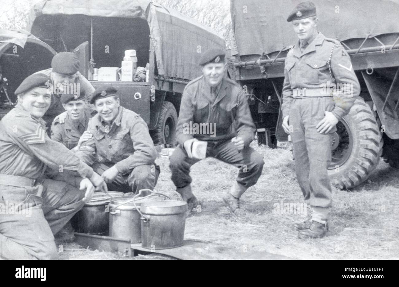 Soldaten des Royal Army Service Corps, 3. Division, warten auf eine Mahlzeit, die von einem Sergeant des Army Catering Corps in Surrey im April 1957 serviert wird. Stockfoto