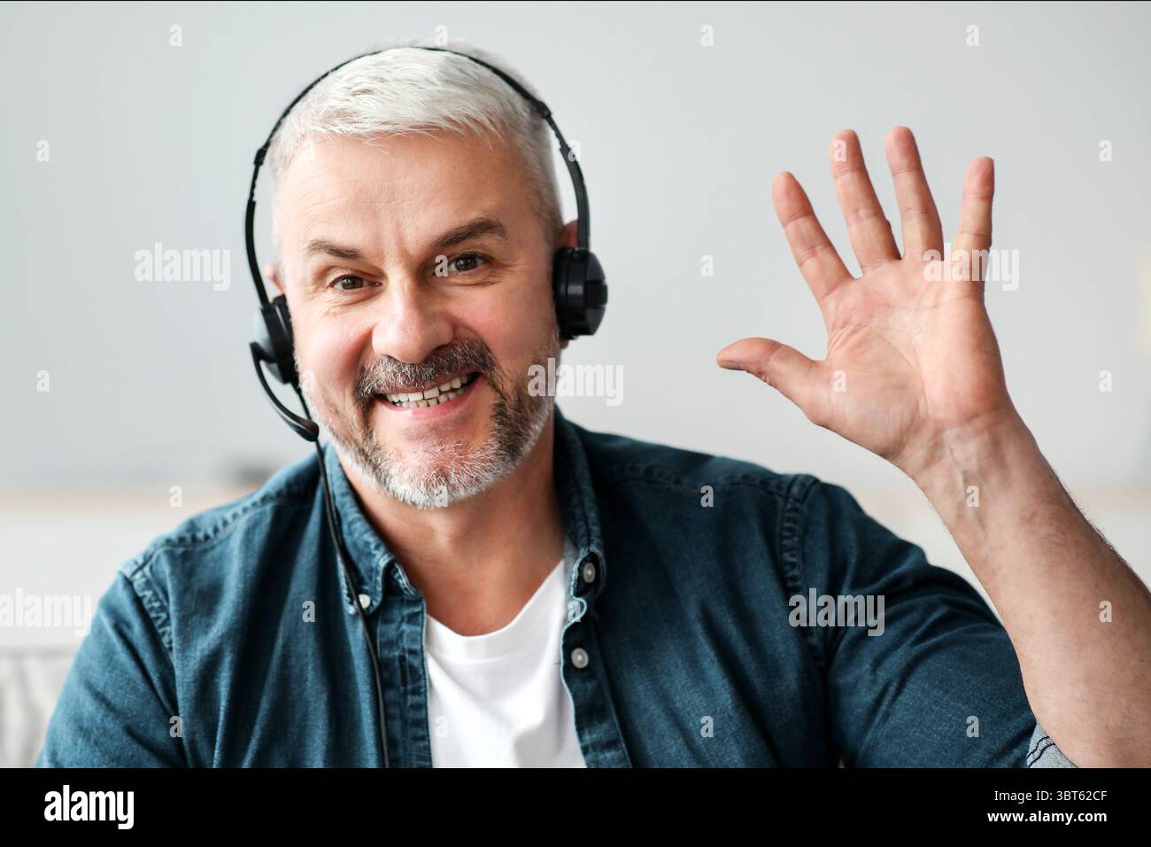 Lächelnder, leitender Mann mit Videoanruf und Headset Stockfoto