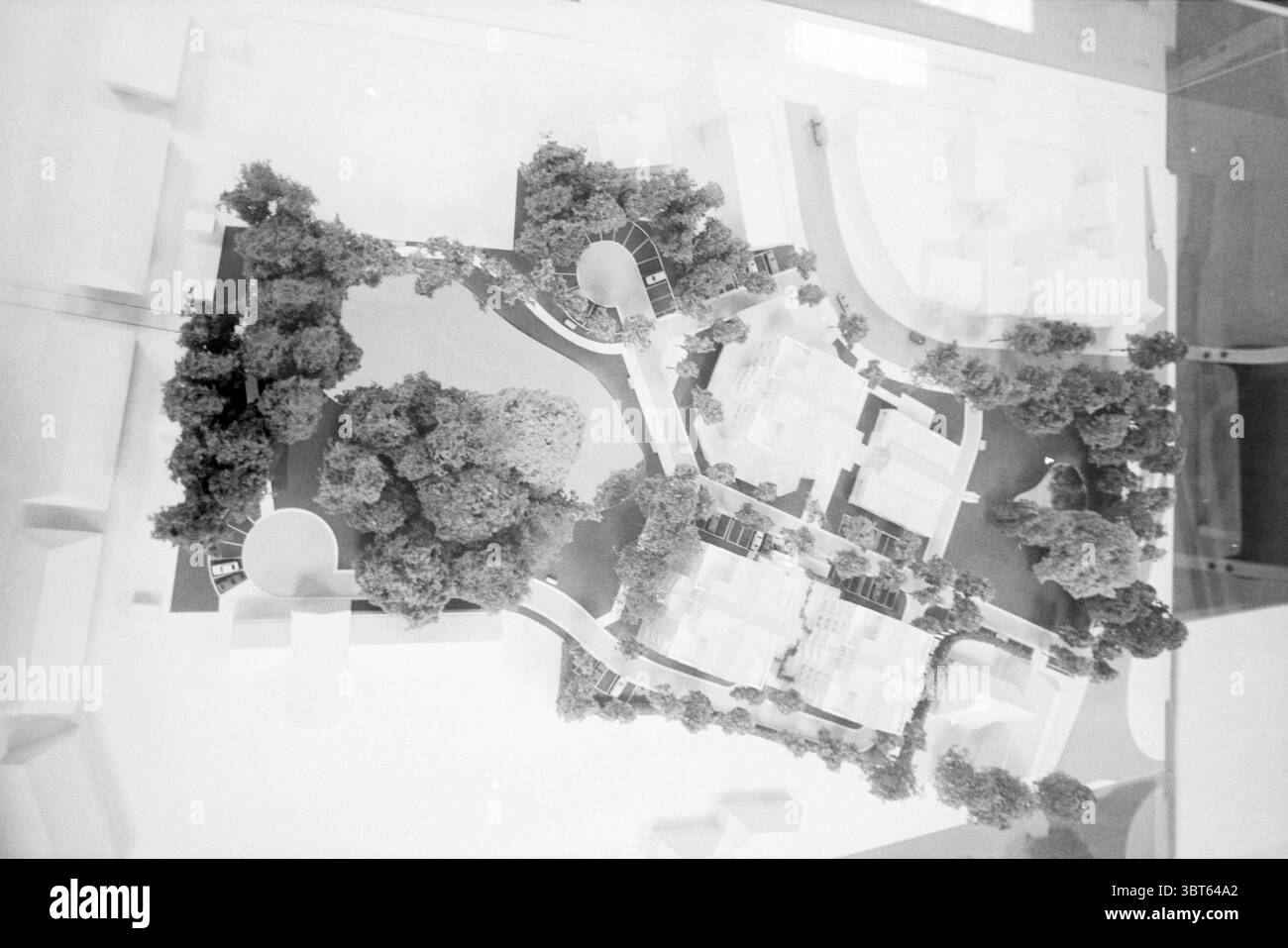 Modell des Rathauses von Bloemendaal Modell Bloemendaal, Whizgle News, Dutch Desk, Niederlande, 1950 - 2000 am 26-09-1988. Die Abbildung zeigt diese Themen. Die Szene zeigt ein detailliertes Architekturmodell, das sorgfältig angeordnet ist, um einen geplanten Außenraum darzustellen. Die Umgebung zeichnet sich durch eine Vielzahl von Elementen aus, die Gebäude, Wege und Landschaftsgestaltung darstellen. Im Zentrum der Komposition befinden sich mehrere weiße Strukturen, die jeweils verschiedene Arten von Gebäuden darstellen, die wahrscheinlich Wohn- oder Gemeinschaftszwecken dienen. Ihr minimalistisches Design steht im Kontrast zum surr Stockfoto