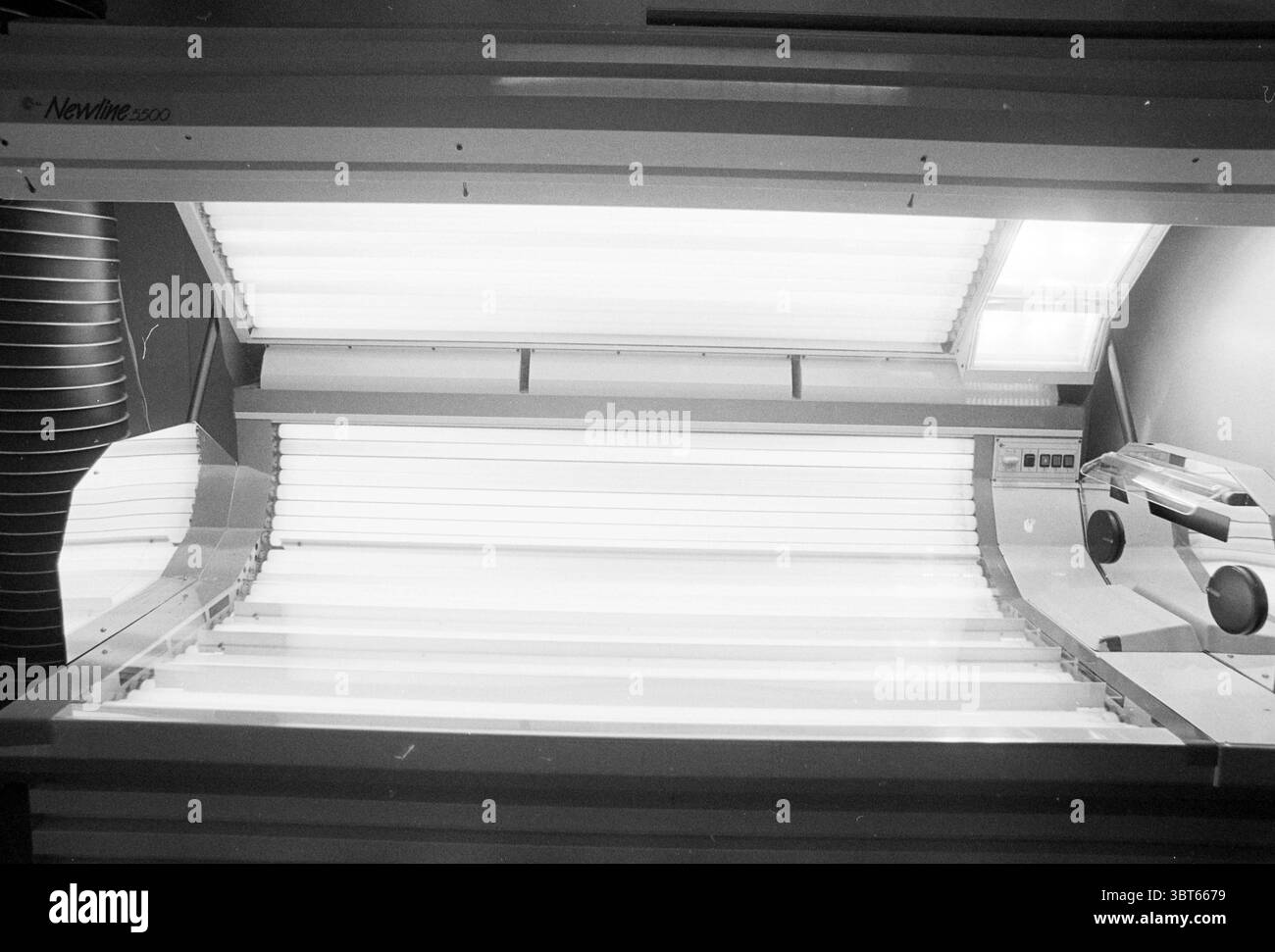 City Sun Centre, Whizgle News, Dutch Desk, Niederlande, 1950 - 2000 am 14-06-1994. Diese Themen sind in der Abbildung dargestellt. Die Szene zeigt ein Solarium im Innenbereich, das sich durch elegante, moderne Designelemente auszeichnet. Das Gerät ist überwiegend weiß, was eine saubere und klinische Ästhetik unterstreicht. Das Bräunungsbett ist verlängert und verfügt über mehrere Reihen von Leuchtstofflampen, die ein helles, weiches Leuchten ausstrahlen. Die Paneele der Sonnenbank sind glatt und wirken reflektierend, was die leuchtende Atmosphäre verstärkt. Die Beleuchtung ist scharf, erzeugt scharfe Kontraste und erzeugt subtile Schatten auf die Oberflächen nea Stockfoto