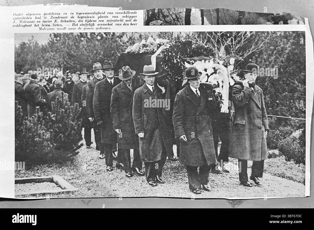 Beerdigung von 2 Skippern, die während einer Übungsfahrt mit dem Rettungsboot Zandvoort ertranken., Whizgle News, Dutch Desk, Niederlande, 1950 - 2000. Dies sind die Themen im Bild. Die Szene zeigt eine düstere Prozession vor einer natürlichen Kulisse. Eine Gruppe elegant gekleideter Männer läuft in einer Schlange, alle tragen dunkle Anzüge und Hüte, die auf einen formellen Anlass hinweisen. Ihre Äußerungen sind ernst und spiegeln eine Stimmung des Festes oder der Erinnerung wider. Vor den Männern wird ein großes, verziertes Tier – wahrscheinlich eine Kuh – geführt, mit Laub oder Blumen überzogen, die dem ansonsten gedämpften p einen Hauch von Grün verleihen Stockfoto