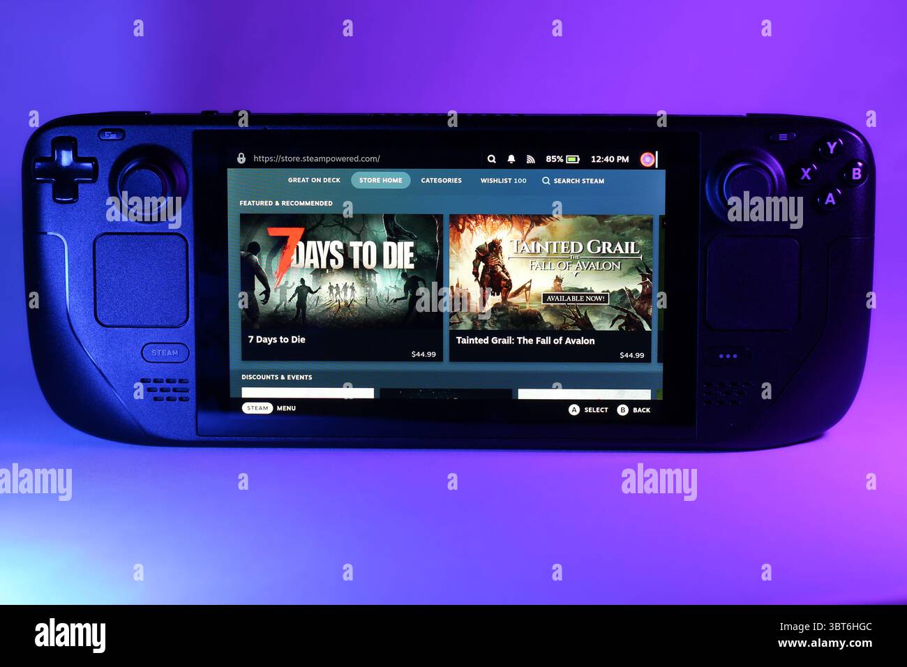 Nahaufnahme der Steam Deck Gaming-Konsole, beleuchtet durch bunte Umgebungsbeleuchtung Stockfoto