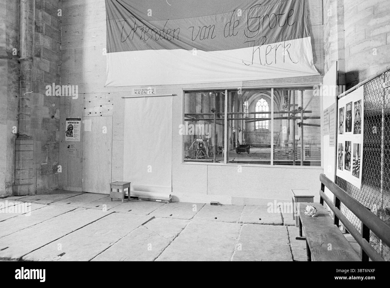 Trennwand + Fenster Grote Kerk Grote Kerk Haarlem Kirchen St. Bavokerk Haarlem Niederlande, Whizgle News, Dutch Desk, Niederlande, 1950 - 2000 am 22-04-1981. Dies sind die Themen im Bild. Die Szene zeigt das Innere einer großen und historischen Kirche, die durch ihre hohen, bogenförmigen Decken und hoch aufragenden Steinmauern gekennzeichnet ist. Die Atmosphäre wirkt sowohl feierlich als auch reflektierend, betont durch die gedämpfte Beleuchtung, die durch die hohen, schmalen Buntglasfenster gefiltert wird, die sanfte Farben auf den Boden werfen. Auf der einen Seite erstreckt sich ein großes Stoffbanner über die Wand, und seine Drapierung macht mich zu etwas Stockfoto