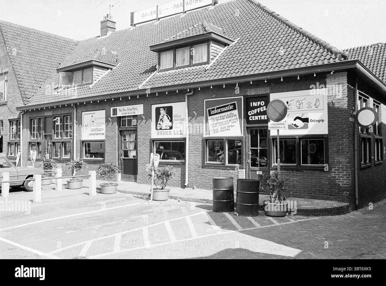 Erw. Atlaspartei Dorpsplein Zandvoort Dorpsplein, Whizgle News, Dutch Desk, Niederlande, 1950 - 2000 am 02-05-1980. Diese Themen werden in der Abbildung angezeigt. Die Szene besteht aus einem charmanten, zweistöckigen Gebäude mit einem unverwechselbaren Giebeldach und einer Ziegelfassade. Das Dach ist mit einer reichen, rötlich-braunen Fliese geschmückt, die zu einem gemütlichen und doch traditionellen Aussehen beiträgt. Die Fenster sind in dunklem Holz eingerahmt und einige sind mit Pflanzen geschmückt, die der rustikalen Ästhetik einen Hauch von Grün verleihen. Im Erdgeschoss zeigen eine Reihe von großen Fenstern das Innere Stockfoto