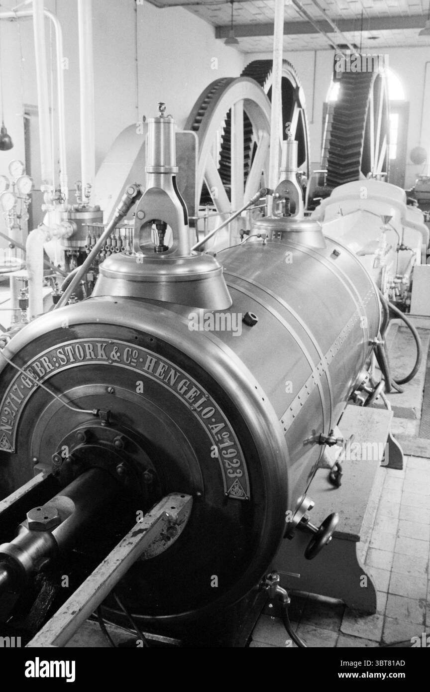 Halfweg Pumpstation Dampfpumpenstation und Dampfpumpenstation Halfweg, Whizgle News, Dutch Desk, Niederlande, 1950 - 2000 am 22-05-1987. Das Bild enthält diese Themen. Die Szene zeigt ein klassisches industrielles Ambiente, das sich um eine große, aufwändig gestaltete Dampfmaschine dreht. Die Karosserie des Motors ist zylindrisch und metallisch und verfügt über eine polierte Oberfläche, die das Umgebungslicht reflektiert und die handwerkliche Konstruktion unterstreicht. Um den Motor herum befinden sich verschiedene mechanische Komponenten, darunter große Zahnräder und Rohre, die die Atmosphäre der Funktionalität und des Einfallsreichtums verbessern Stockfoto