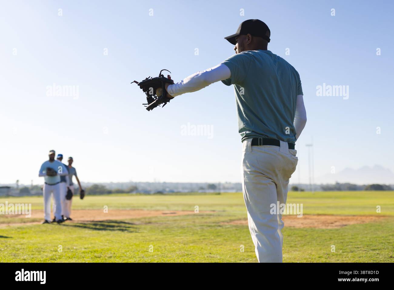 Afroamerikanischer Baseballspieler, der den Handschuh ausdehnt, während er auf das Feld wartet, Kopierraum Stockfoto