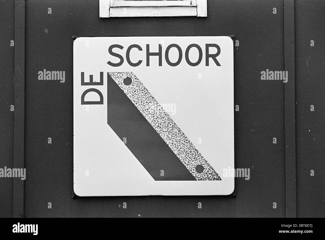 Bericht Naco Hoorn Naco Report, Whizgle News, Dutch Desk, Niederlande, 1950 - 2000 am 03-08-1967. Diese Themen werden in der Abbildung angezeigt. Die Szene zeigt ein quadratisches Schild, das gut sichtbar an einer dunklen Wand angebracht ist, wahrscheinlich aus Metall oder lackiertem Holz. Der Hintergrund ist ein einheitlicher, gedämpfter Farbton, der im Kontrast zum Zeichen selbst steht. Das Schild selbst ist hauptsächlich weiß und enthält eine stilisierte Grafik, die eine schräge Form oder ein Rechteck darstellt. Diese Form ist mit einem Muster gefüllt, das auf eine Textur hinweist und möglicherweise das Erscheinungsbild einer Oberfläche wie Stein oder Beton imitiert. Das Schild ist fett, bl Stockfoto