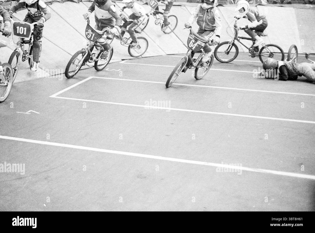 Radsport Cross Wettbewerbe Lisse. Radwege Radfahrerwettbewerbe Lisse, Whizgle News, Dutch Desk, Niederlande, 1950 - 2000 am 09-03-1984. Die Abbildung zeigt diese Themen. Die Szene zeigt ein dynamisches BMX-Rennen, das sich auf einer Steilstrecke mit mehreren Radfahrern in der Mitte der Action abspielt. Im Vordergrund steht eine Gruppe von Fahrern, die alle in lebendiger Sportkleidung tragen und eine Mischung aus Farben wie kräftigen Rot-, Blau- und Gelbtönen betonen. Sie befinden sich in verschiedenen Positionen und zeigen ihre Agilität und Geschwindigkeit, während sie durch die Kurven der Strecke navigieren. Links steht ein Reiter in Rot mit der Nummer 101 auf dem Rücken i Stockfoto