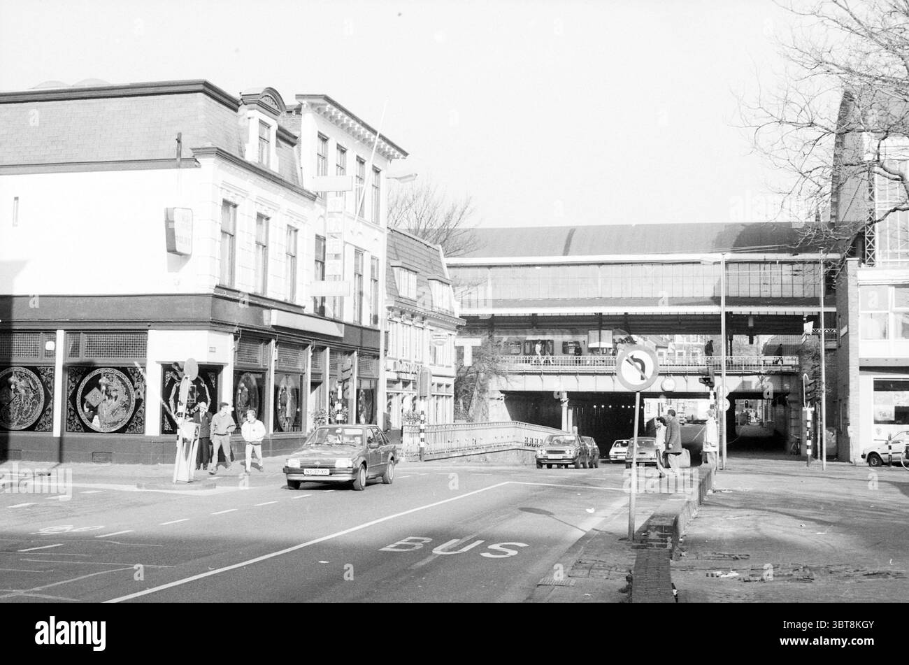 EXT. Restaurant Chang Au Kruisweg Haarlem Restaurant Haarlem Kruisweg Niederlande, Whizgle News, Dutch Desk, Niederlande, 1950 - 2000 am 08-02-1989. Dies sind die Themen im Bild. Die Szene zeigt eine geschäftige urbane Kreuzung, die durch eine Mischung aus Architektur und Aktivität gekennzeichnet ist. Auf der einen Seite steht ein zweistöckiges Gebäude mit großen Fenstern, die dekorative Elemente, möglicherweise Kunst oder Ausstellungen, zeigen. Die Fassade hat eine Mischung aus dunklen Farben mit Akzenten, die auf einen Vintage-Stil hinweisen könnten, was die Aufmerksamkeit auf seine bedeutende Präsenz lenkt. Im Vordergrund läuft eine Straße hori Stockfoto