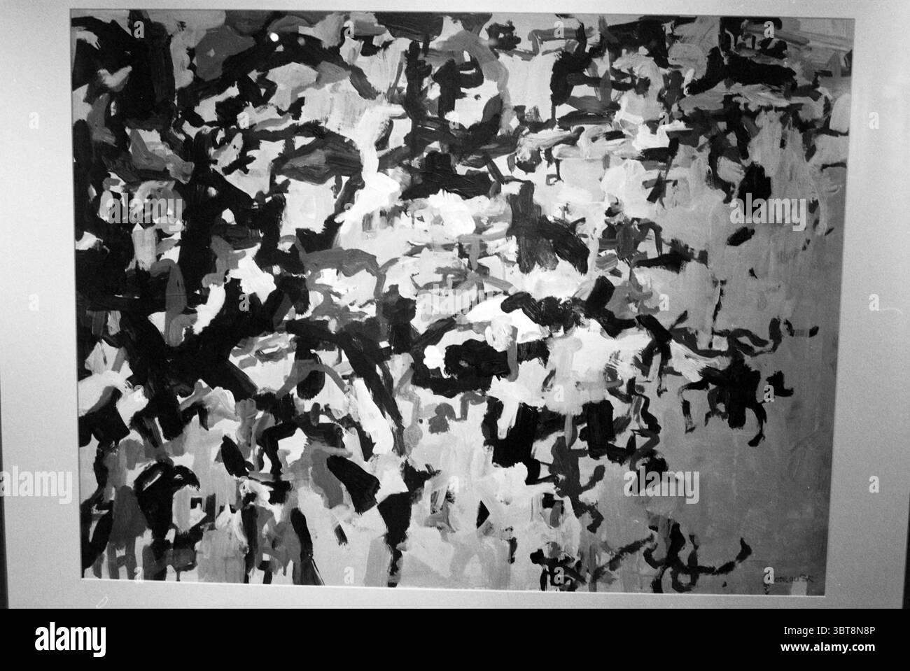 Kunst im Rathaus Bloemendaal Bloemendaal, Whizgle News, Dutch Desk, Niederlande, 1950 - 2000 am 20-03-1992. Dies sind die Elemente im Bild. Die Szene zeigt eine abstrakte Komposition, die von einem dynamischen Zusammenspiel von Schwarz, weiß und verschiedenen Grautönen dominiert wird. Die Leinwand ist mit energischen Pinselstrichen und strukturierten Farbaufträgen gefüllt, die ein Gefühl von Bewegung und Tiefe erzeugen. Im Vordergrund weben sich kräftige, dunkle Striche ein und aus, die organische Formen bilden, die Figuren oder Formen andeuten, ohne explizit definiert zu werden. Diese dunkleren Elemente bilden einen starken Kontrast zu den helleren Bereichen Stockfoto