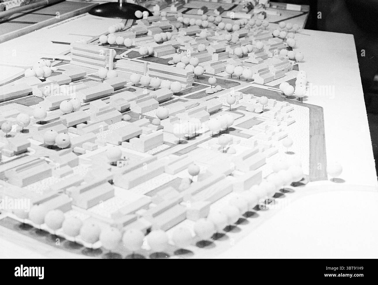 Der stadtrat von Haarlem diskutiert neue Baupläne mit einem Modell Haarlem the Netherlands, Whizgle News, Dutch Desk, Niederlande, 1950 - 2000 am 23-04-1971. Die Abbildung zeigt diese Themen. Die Szene zeigt ein detailliertes Architekturmodell auf einer Ebenen Fläche. Das Modell zeigt eine geplante städtische Umgebung mit verschiedenen Strukturen, die in einer monochromatischen Palette von weiß und Hellgrau dargestellt sind. Diese Strukturen variieren in Größe und Form, was auf eine Mischung aus Wohn-, Gewerbe- und institutionellen Gebäuden hindeutet. Üppiges Grün wird durch kleine, abgerundete Cluster angezeigt, die an Tre erinnern Stockfoto