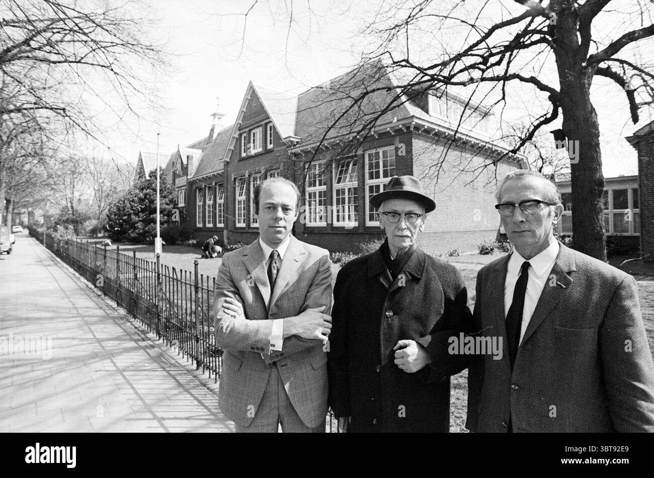 3 Generationen von St. Joseph School Persons Schools, Whizgle News, Dutch Desk, Niederlande, 1950 - 2000 am 24-04-1972. Das Bild enthält diese Themen. Die Szene zeigt drei Männer, die zusammen vor einem Backsteingebäude stehen, das einen unverwechselbaren architektonischen Stil aufweist, der an das Design des frühen 20. Jahrhunderts erinnert. Das Gebäude zeichnet sich durch sein eckiges Dach, die markanten Giebeln und die großen Fenster aus, die ein Gefühl klassischer Eleganz widerspiegeln. Im Vordergrund posiert das Männertrio selbstbewusst. Jedes Modell zeigt einen anderen Kleidungsstil und zeigt eine Vielzahl von Anzügen und Oberbekleidung, die typisch für das P Stockfoto