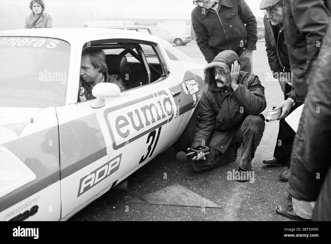 TNO Inspektionskreis Zandvoort Circuit Zandvoort Inspections, Whizgle News, Dutch Desk, Niederlande, 1950 - 2000 am 06-11-1978. Diese Themen sind in der Abbildung dargestellt. In einem knalligen, monochromen Ambiente dominiert ein Oldtimer den Vordergrund, dessen schlanke, kurvige Karosserie eine Mischung aus auffälligen, auffälligen Farben zeigt – vor allem weiß mit auffälligen Rot- und Blautönen. Das Design des Fahrzeugs vermittelt ein Gefühl von Geschwindigkeit und Geschichte, das für den klassischen Motorsport charakteristisch ist. Im Inneren des Fahrzeugs ist ein Fahrer in einem Rennanzug fokussiert und mit einem entschlossenen Ausdruck, der auf konzentrierte Konzentration hindeutet Stockfoto