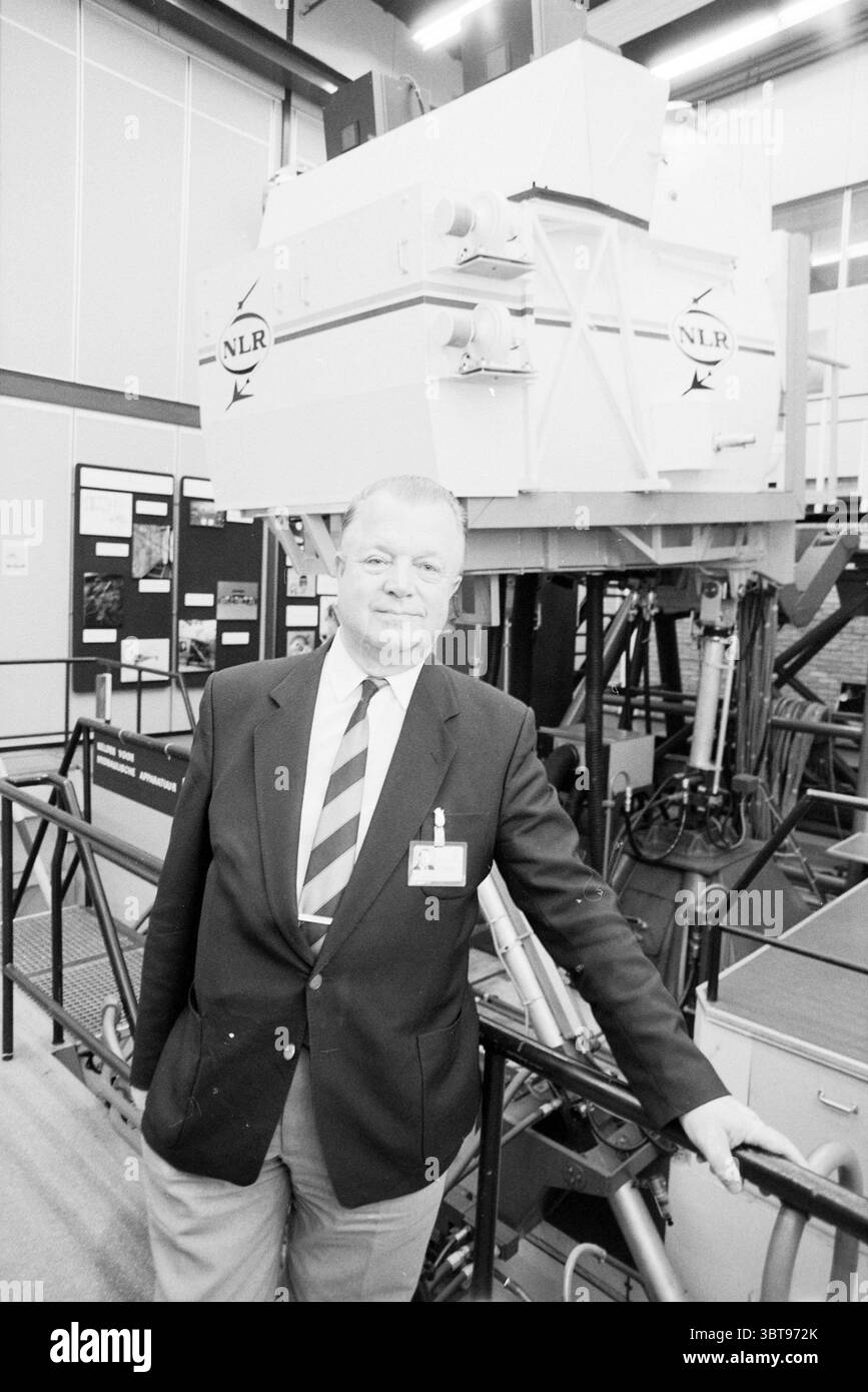 Prof. Gerlach N.L.R. A'Dam Amsterdam the Netherlands, Whizgle News, Dutch Desk, Niederlande, 1950 - 2000 am 29.09.1991. Diese Themen werden in der Abbildung angezeigt. Die Szene zeigt einen Mann, der selbstbewusst neben einem großen, industriellen Gerät steht, das zu einer Technologie- oder Forschungseinrichtung gehört. Er trägt ein formelles Outfit, bestehend aus einem dunklen Anzug, ergänzt durch eine gestreifte Krawatte, die seinem Kleidungsstück einen Hauch von Farbe verleiht. Sein Ausdruck vermittelt ein Gefühl von Professionalität und Stolz, was darauf hindeutet, dass er mit der Maschine neben ihm vertraut ist. Das Gerät selbst Stockfoto