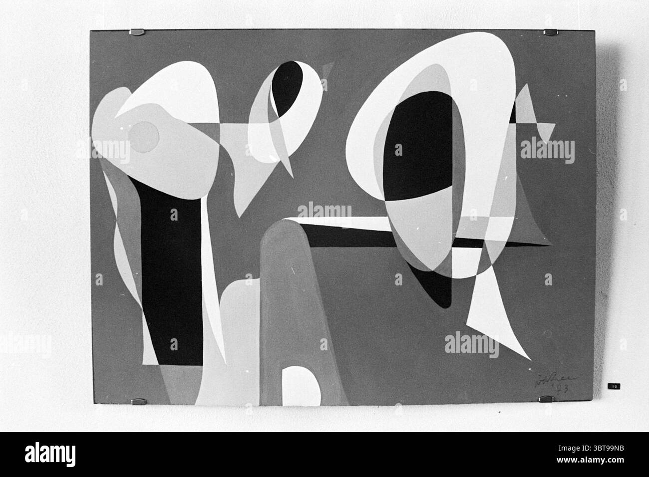 Foto der modernen Malerei., Whizgle News, Dutch Desk, Niederlande, 1950 - 2000 im Jahr 1973. Die Abbildung zeigt diese Themen. Die Szene zeigt ein abstraktes Kunstwerk, das vor einer hellen Wand sichtbar ist. Die Komposition besteht aus einer Reihe von fließenden Formen und Formen, die ein dynamisches Zusammenspiel von Kurven und Winkeln erzeugen. Das Kunstwerk zeigt überwiegend eine gedämpfte Farbpalette, in der weiche weiß-, Schwarz- und Grautöne die Leinwand dominieren, durchsetzt mit gelegentlichen tiefen, satten Tönen, die Tiefe verleihen. Diese Farben werden in einer Nebeneinanderstellung angewendet, die ein Gefühl von Balance und Kontrast erzeugt. Stockfoto