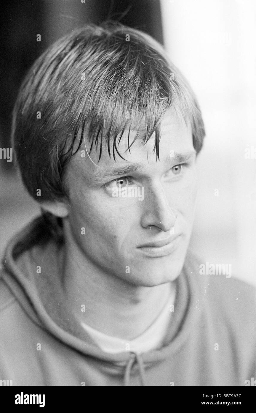 Kees Jan Diepenveen Hockeyspieler Hockey, Whizgle News, Dutch Desk, Niederlande, 1950 - 2000 am 19.10.1977. Dies sind die Themen im Bild. Ein junger Mann sitzt in besinnlicher Pose und zeigt eine zarte Mischung von Emotionen auf seinem Gesicht. Sein kurzes, zerzaustes Haar wirkt leicht feucht, was auf eine kürzliche Aktivität oder vielleicht eine Atmosphäre voller Feuchtigkeit hindeutet. Die Haut seines Gesichts ist hell und mit feinen Linien verziert, die sowohl auf Jugend als auch auf einen Hauch von Sorge oder Introspektion hinweisen. Seine hellblauen Augen sind auffällig und vermitteln ein Gefühl von Verletzlichkeit und Tiefe. Sie sind leicht heruntergefahren, Sugges Stockfoto