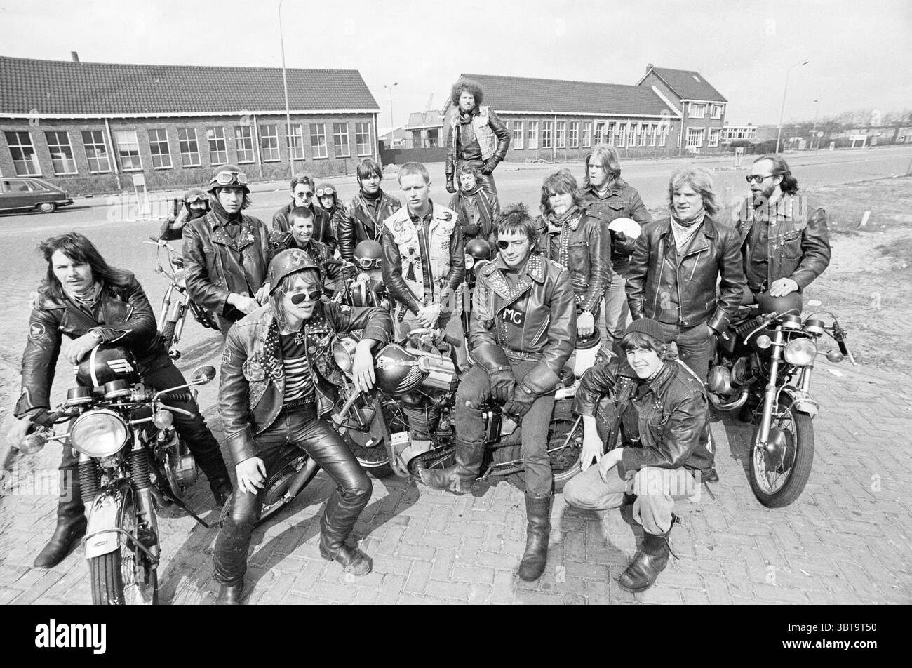 Hells Angels in Haarlem Groups Jugend- und Jugendspiele, Whizgle News, Dutch Desk, Niederlande, 1950 - 2000 am 05-04-1975. Dies sind die Themen im Bild. Eine Gruppe von Individuen steht in einem dynamischen und temperamentvollen Arrangement, das ein Gefühl von Kameradschaft und Rebellion verkörpert. Die meisten sind in dunklen Lederjacken gekleidet, die zu der insgesamt robusten Ästhetik beitragen. Die Kleidung weist oft verschiedene Patches und Verzierungen auf, die auf unterschiedliche Identitäten und Zugehörigkeiten innerhalb der Gruppe hinweisen. Die Umgebung scheint ein offener Bereich zu sein, wahrscheinlich ein Parkplatz, mit einem Hintergrund aus niedrigen Gebäuden Stockfoto