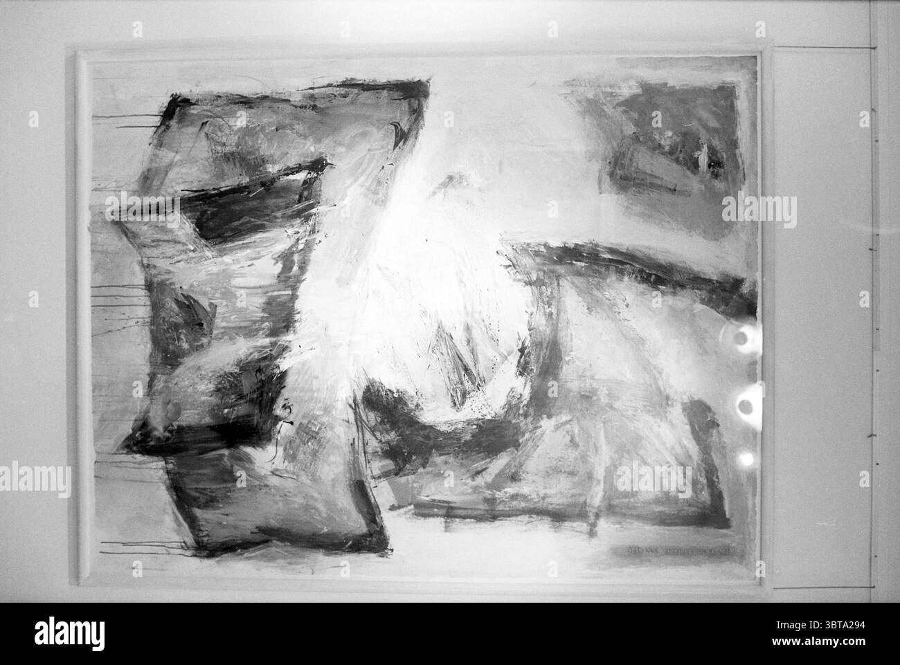 Gemäldegalerie lange Annastraat Haarlem lange Annastraat the Netherlands, Whizgle News, Dutch Desk, Niederlande, 1950 - 2000 am 04-09-1991. Dies sind die Themen im Bild. Die Szene zeigt eine abstrakte Komposition, die von Schwarz-, weiß- und Grautönen dominiert wird. Wirbelnde Formen und zerklüftete Formen erzeugen ein dynamisches Gefühl der Bewegung auf der Leinwand. Die Pinselstriche sind fett und ausdrucksstark, mit unterschiedlichen Texturen, die sowohl Spannung als auch Fließfähigkeit suggerieren. In der Mitte werden hellere Bereiche in dunkleren Konturen überlagert, was dem visuellen Raum Tiefe und Komplexität verleiht. Der Kontrast zwischen li Stockfoto