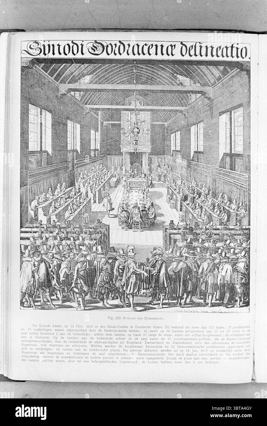 Porträt der Synode in Dordrecht 13. November 1618., Whizgle News, Dutch Desk, Niederlande, 1950 - 2000. Diese Themen sind in der Abbildung dargestellt. Die Szene zeigt einen großen Saal mit zahlreichen Personen, die an langen, systematisch angeordneten Tischen sitzen. Die Architektur verfügt über hohe Fenster, die natürliches Licht einströmen lassen und eine helle und luftige Atmosphäre schaffen. Die hohe Decke ist mit komplizierten Designs verziert, die die Pracht der Einrichtung noch verstärken. Im Vordergrund steht eine Gruppe von Personen, die in formeller Kleidung gekleidet sind, für verschiedene Personen, die an Diskussionen teilnehmen. Ihre Ex Stockfoto